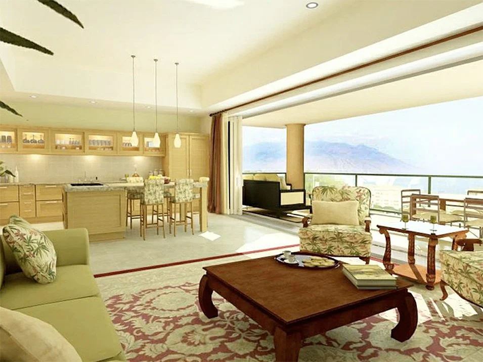 Living area with a sofa, armchair, coffee table, and open kitchen with a bar, all overlooking a balcony with outdoor furniture and a mountain view.