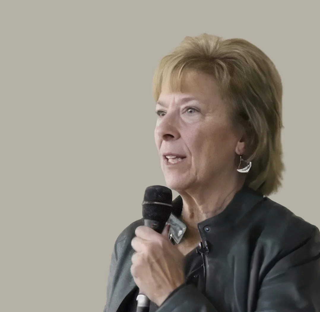 Author Gael Garbarino Cullen speaking into a handheld microphone while wearing a black jacket.