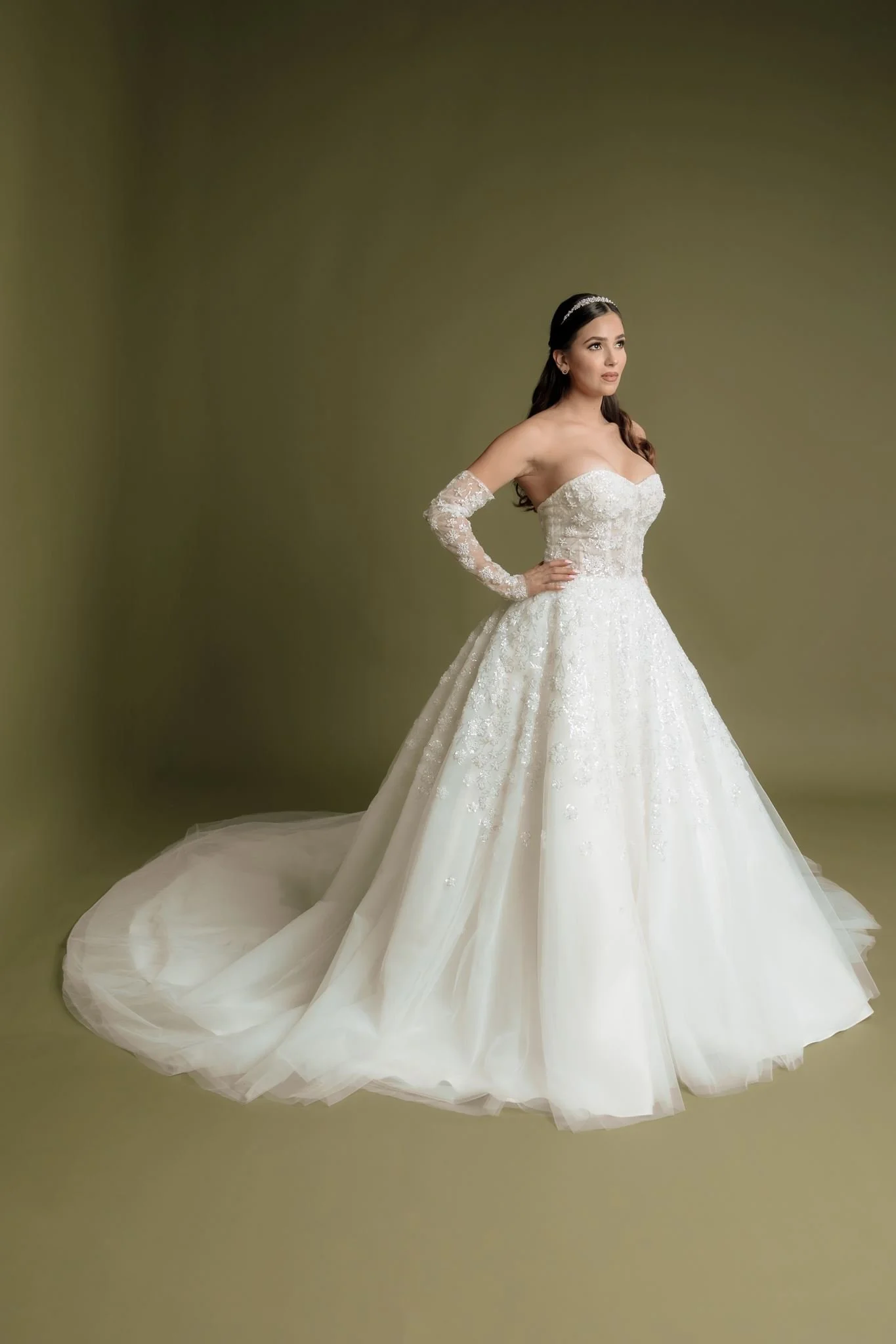 Mujer con vestido de novia de encaje y tul, de espaldas, con salón de fondo