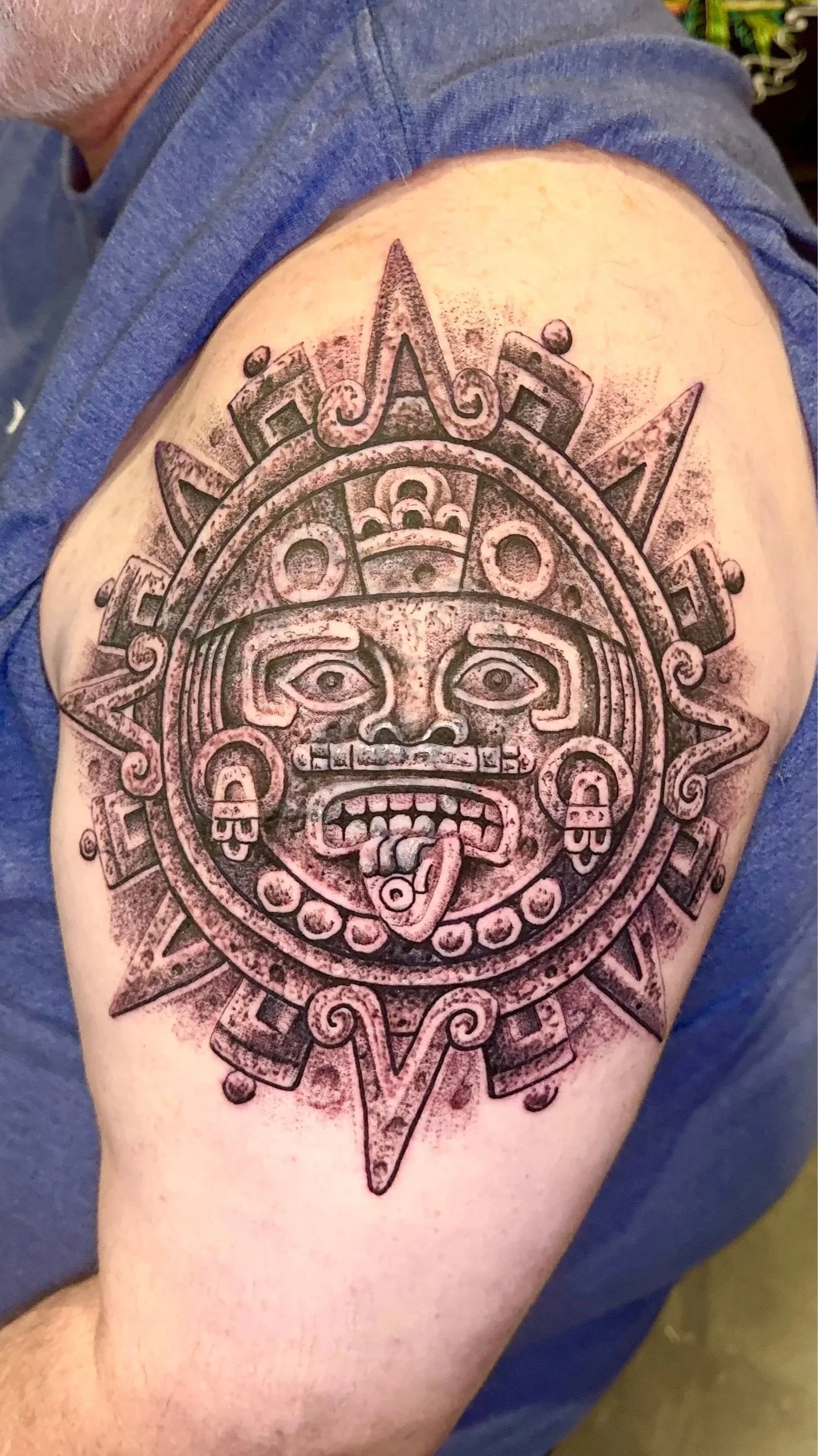 Aztec calender shoulder tattoo with stone texture