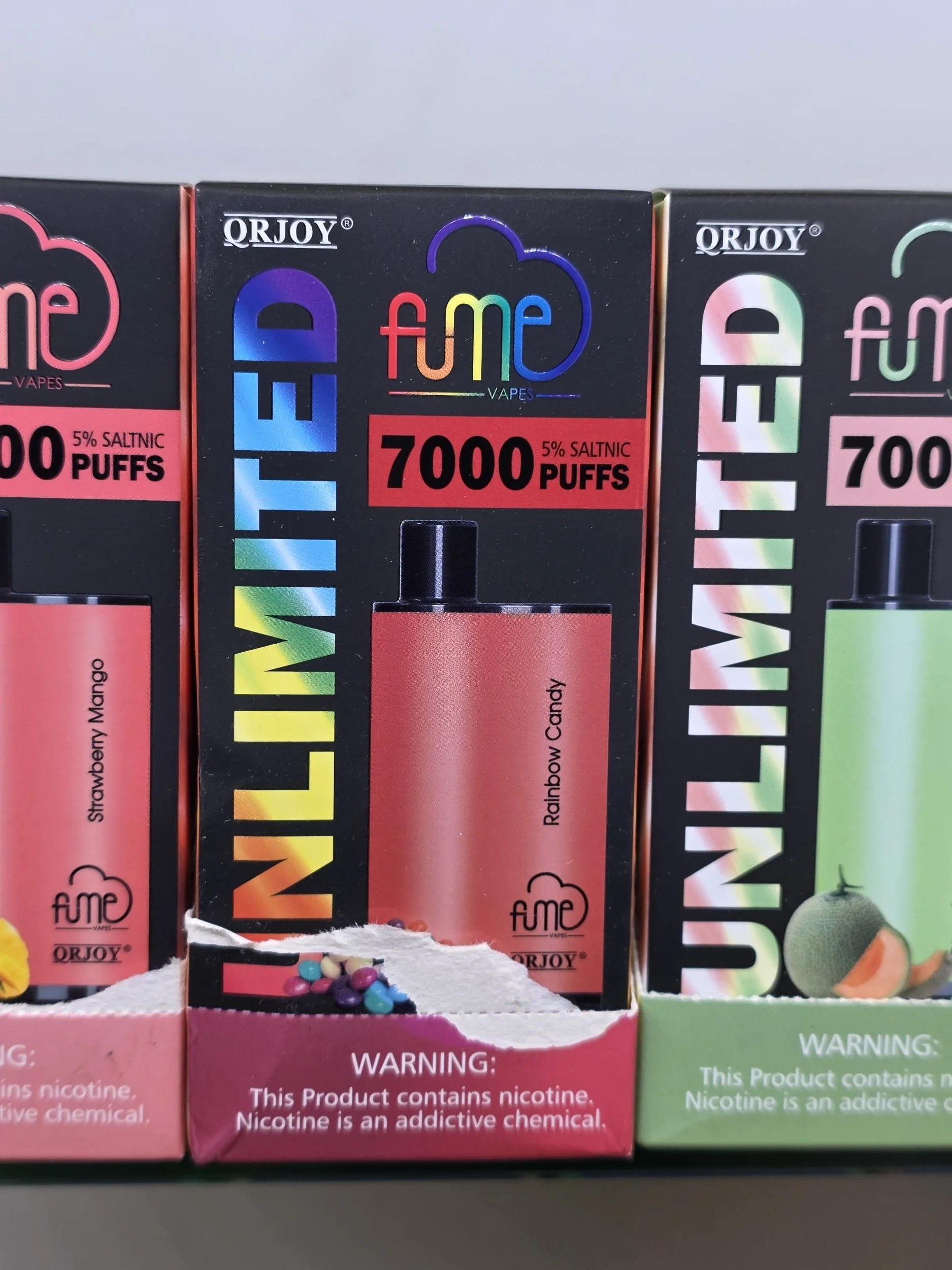 Boxes of flavored nicotine vape products with colorful packaging and warning labels.