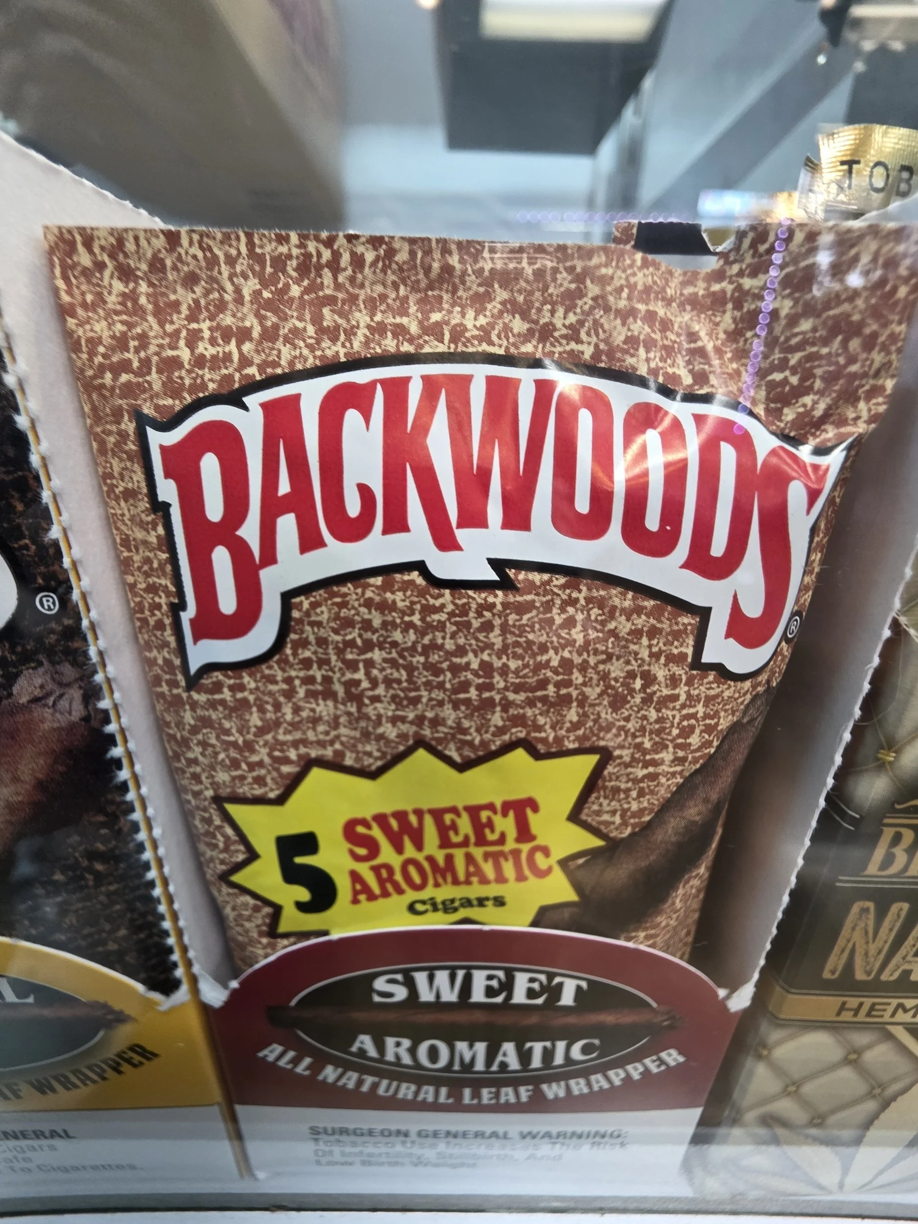 Packaging of Backwoods Sweet Aromatic cigar wraps with a red and brown design and text highlighting the flavor as sweet aromatic.