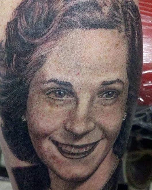 Portrait Tattoo of a 1950's style woman with curled hair and a big smile.
