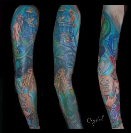 Colorful full sleeve tattoo of The Pirates of the Caribbean featuring dragons, castles, and mythical creatures.