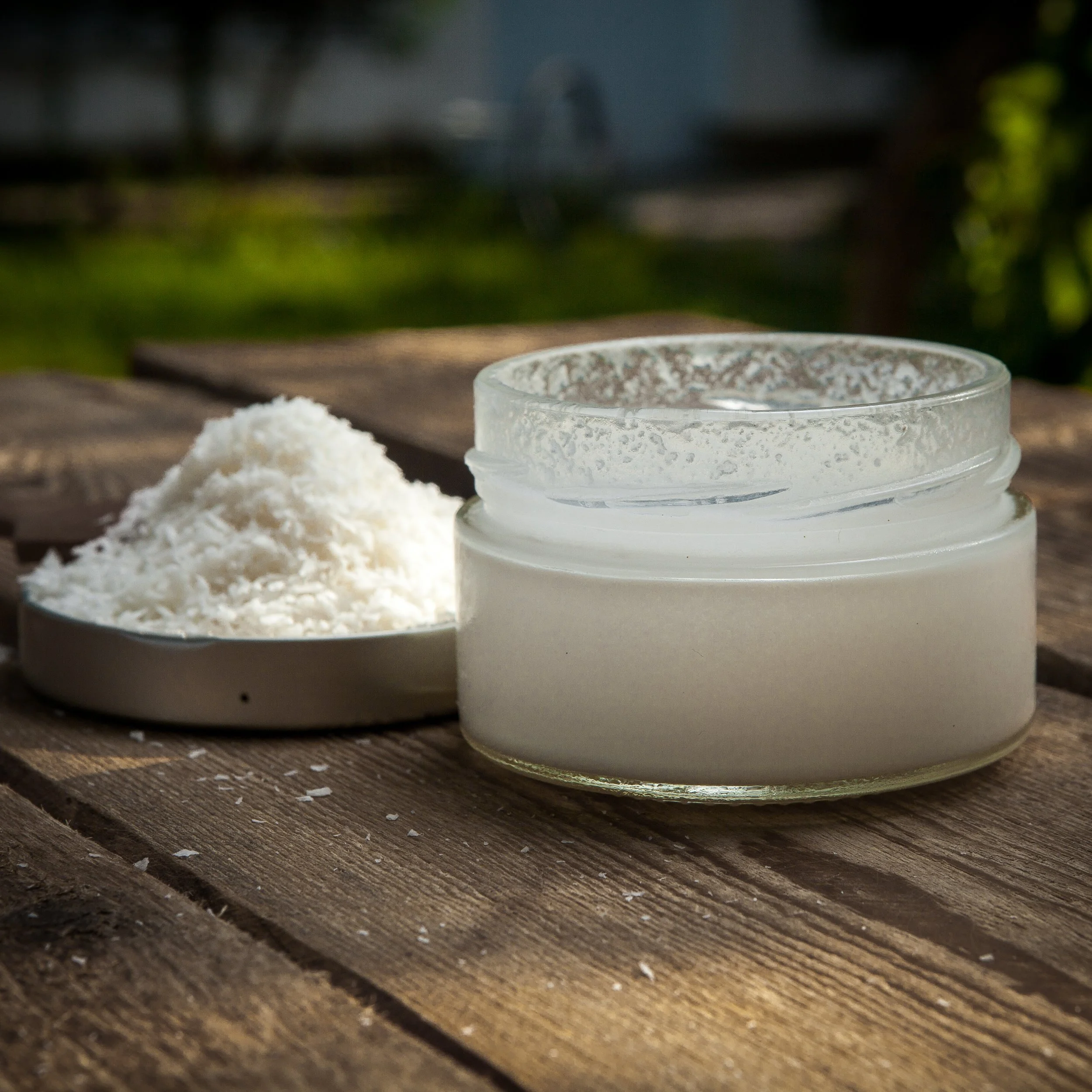 side-view-coconut-milk-with-jar-coconut-crumbs-lid-wooden-table.jpg