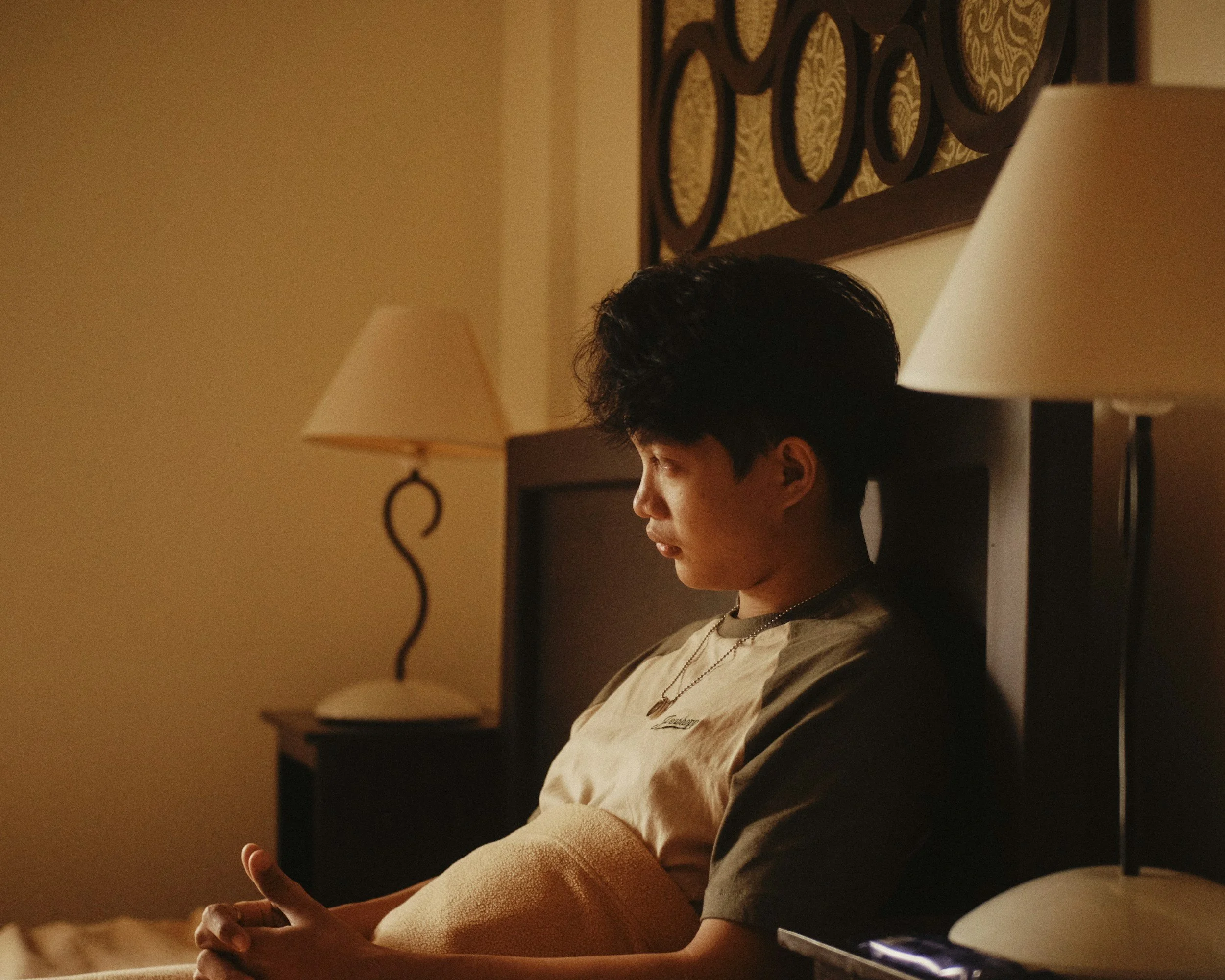 A minimalist, grounding photograph of a person sitting calmly to illustrate a moment of pausing, breath regulation, and checking in with the nervous system.