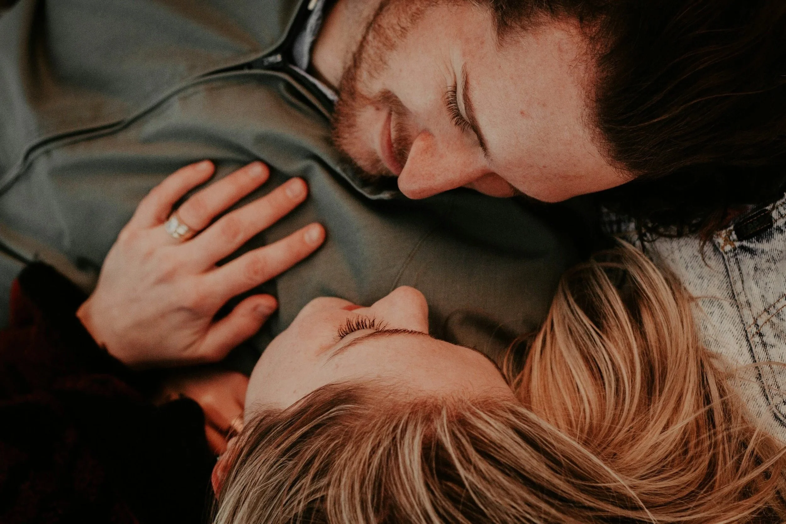 Two people sitting close together in a warm, relaxed environment, illustrating low stakes physical connection and relationship teamwork.