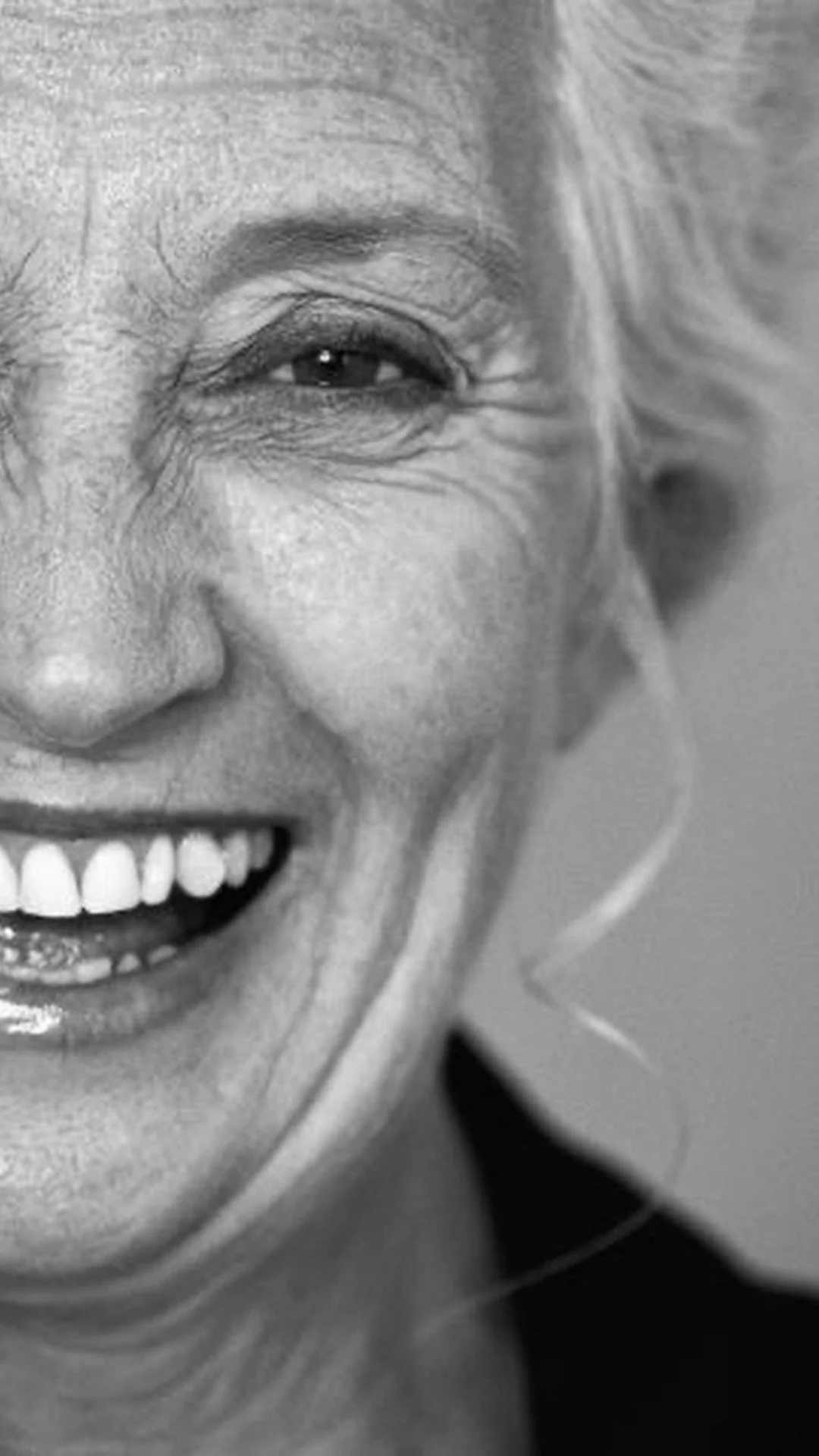 A mature woman in profile softly smiling, representing somatic healing and intimacy across all ages.