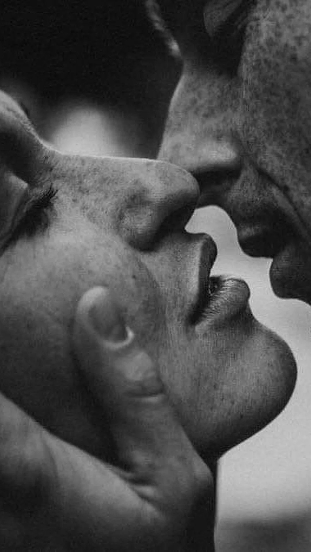 Close-up of a couple tenderly touching faces before a kiss, illustrating physical presence and somatic intimacy.