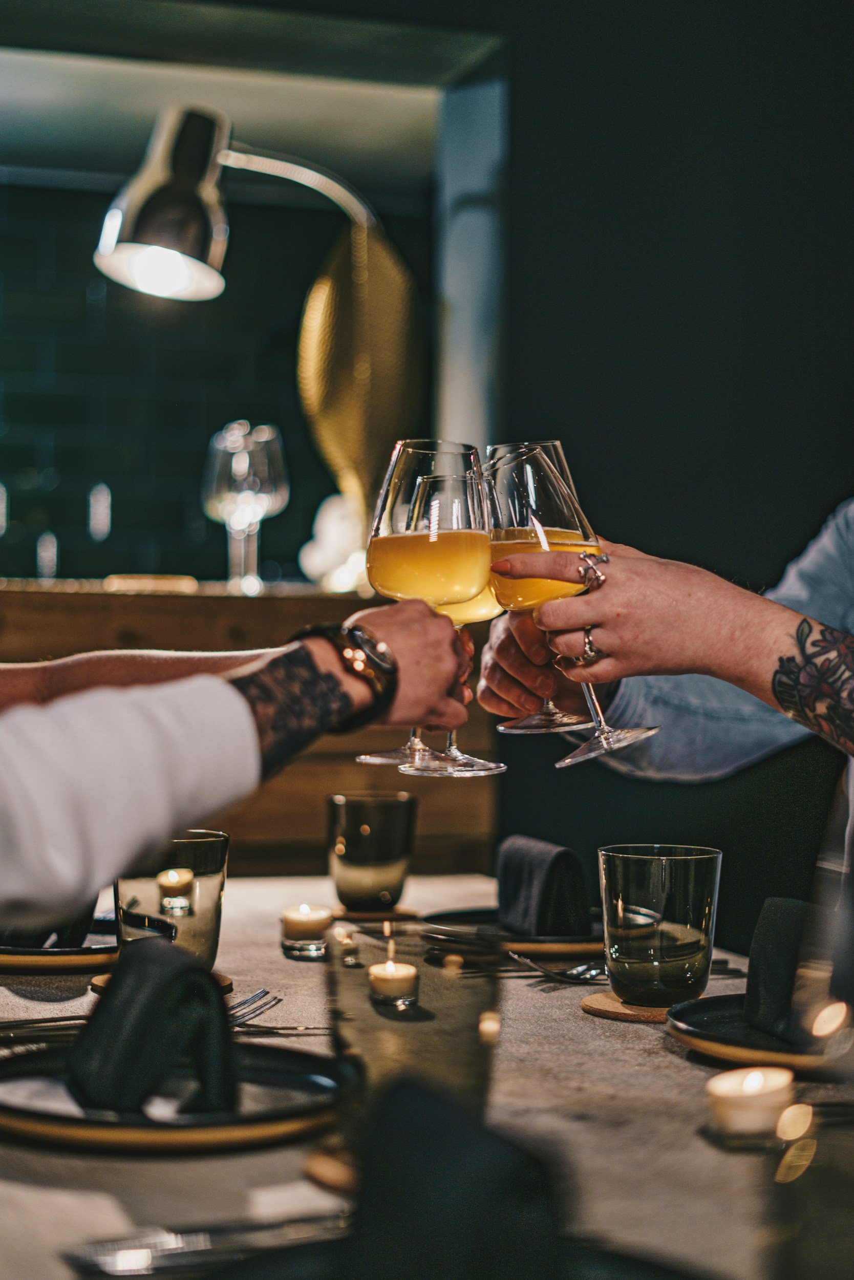 Kädet, joissa oluttuopit käsissä kilistelevät toistensa kanssa.