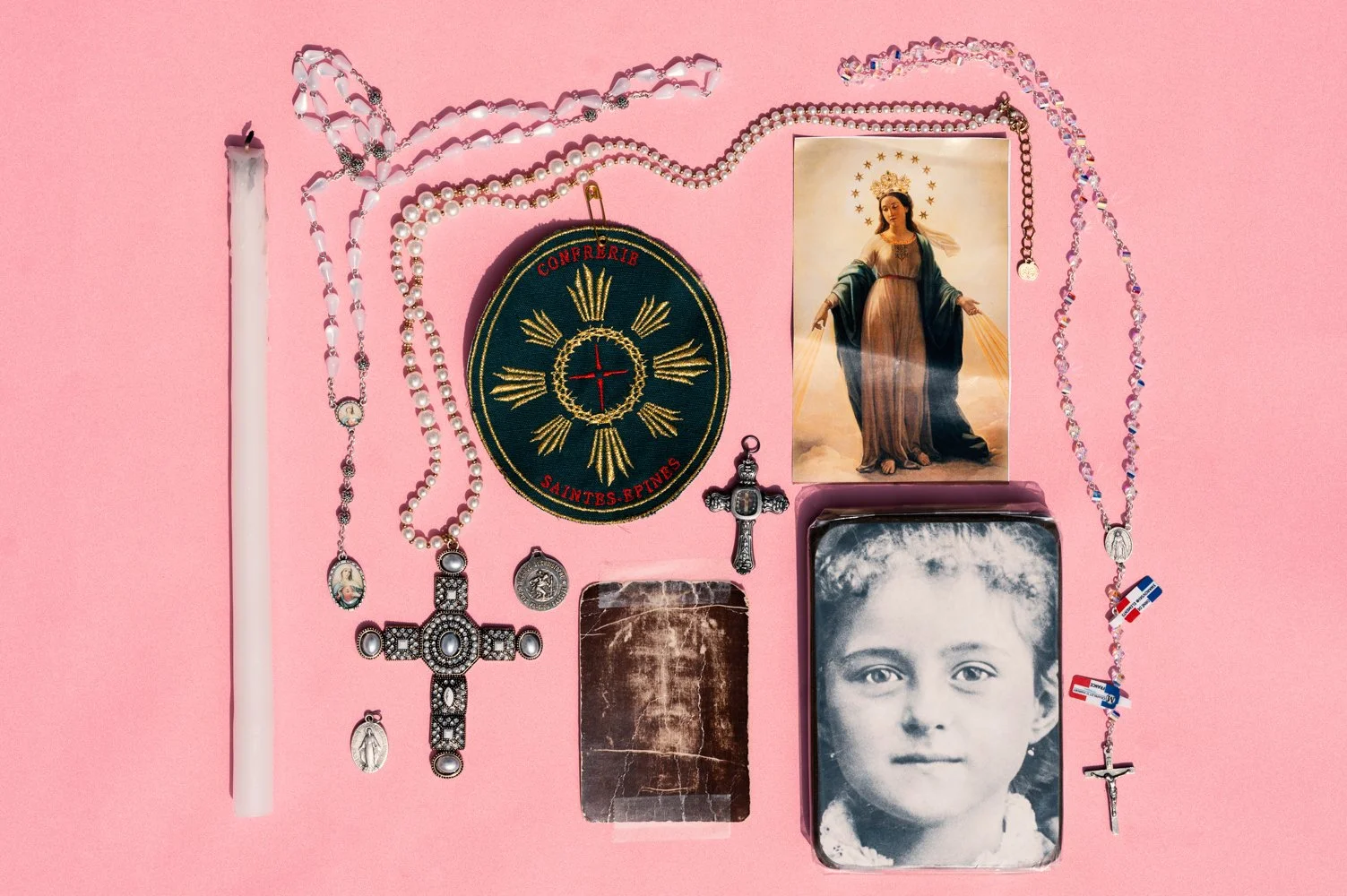 Objets religieux chers à Catherine : chapelets, images pieuses, cierge, et l’écusson de la confrérie des Saintes-Épines à laquelle elle appartient. 