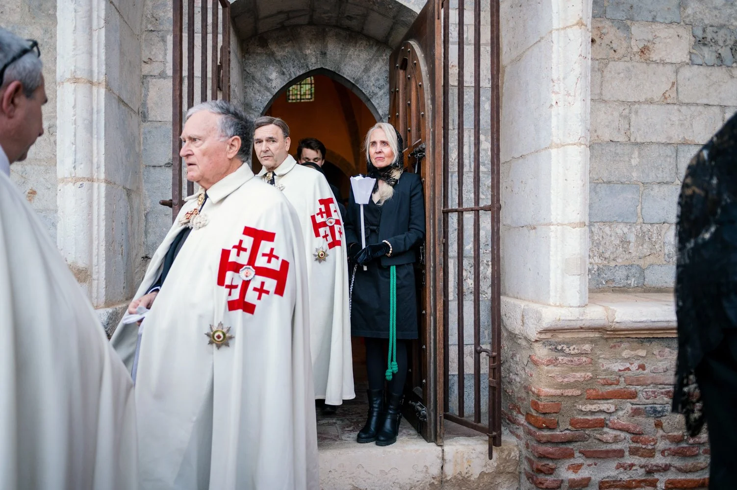 Comme chaque année, Catherine participe au chemin de croix à Perpignan. Le 16 avril 2025, elle attend que la cérémonie commence entre les portes du Campo Santo.
