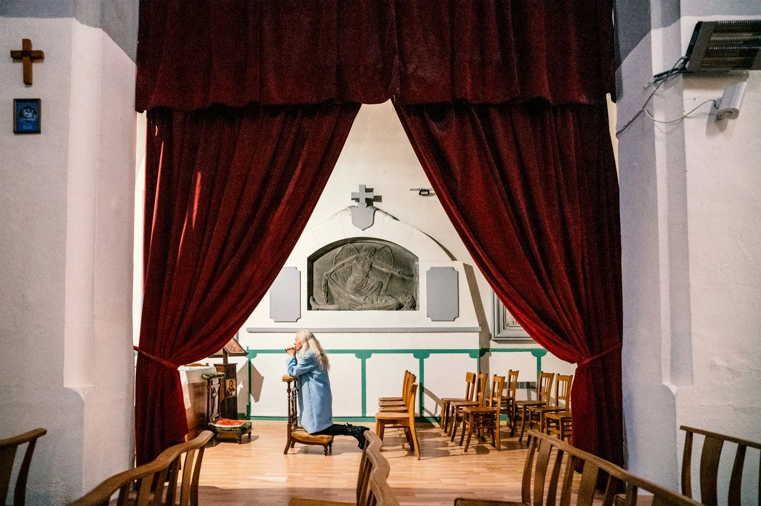Catherine agenouillée, prie devant le corps du Christ à l'eglise Saint-François d'Assise, dans le quartier du Bas-Vernet a Perpignan.