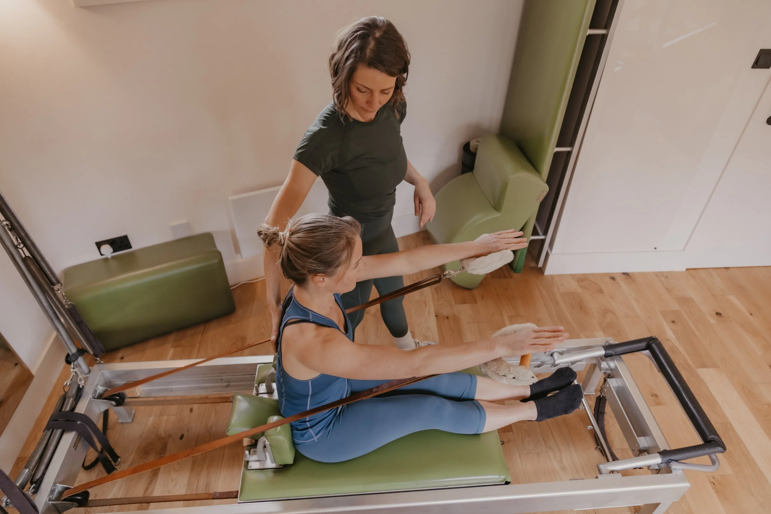 Woman using reformer machine during Pilates class