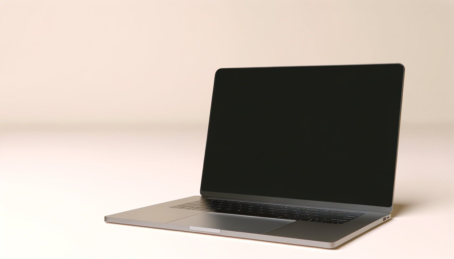 A sleek silver laptop with a black screen on a plain light-colored background.