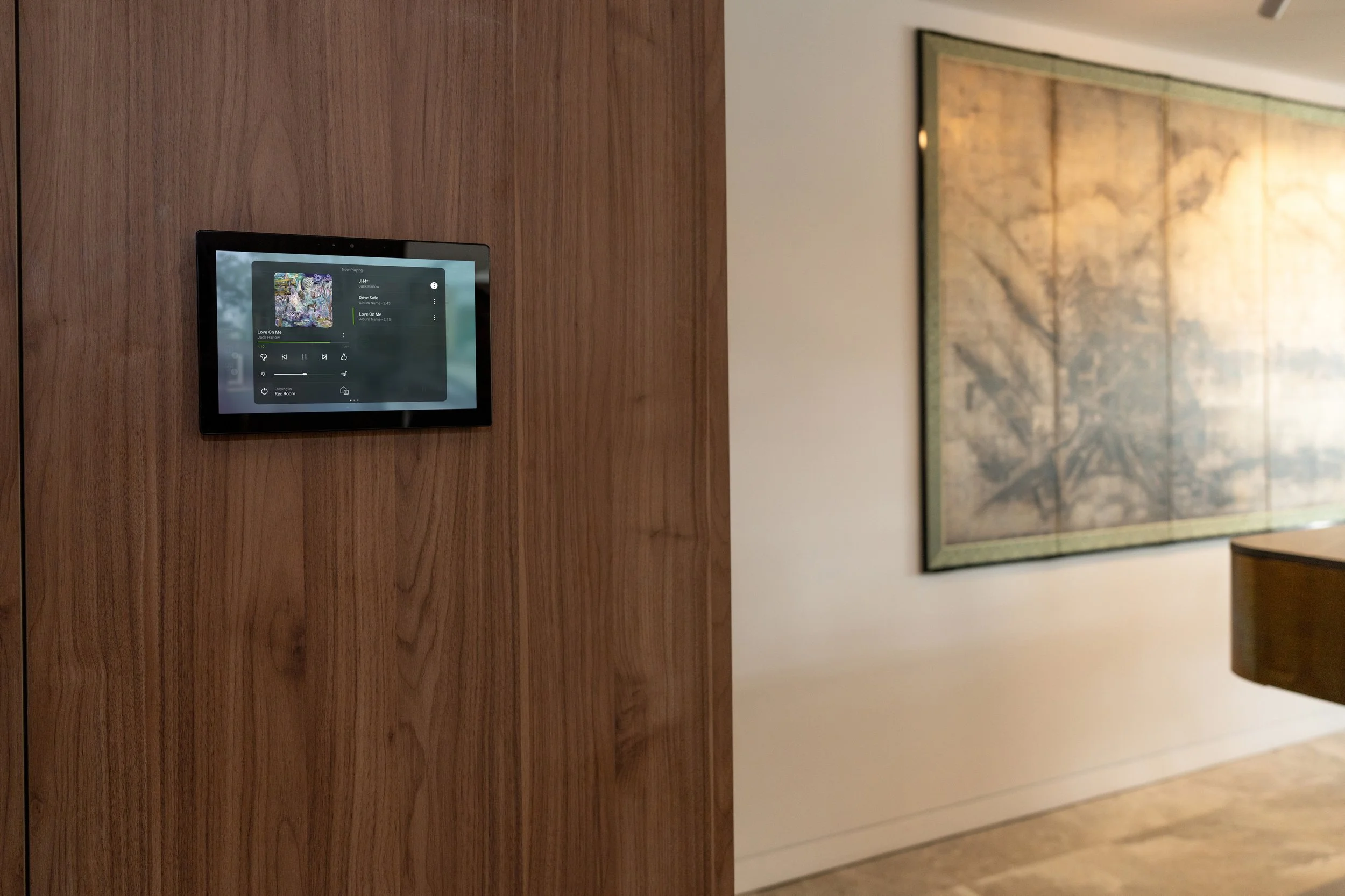 Smart home device mounted on a wooden wall in an interior room.