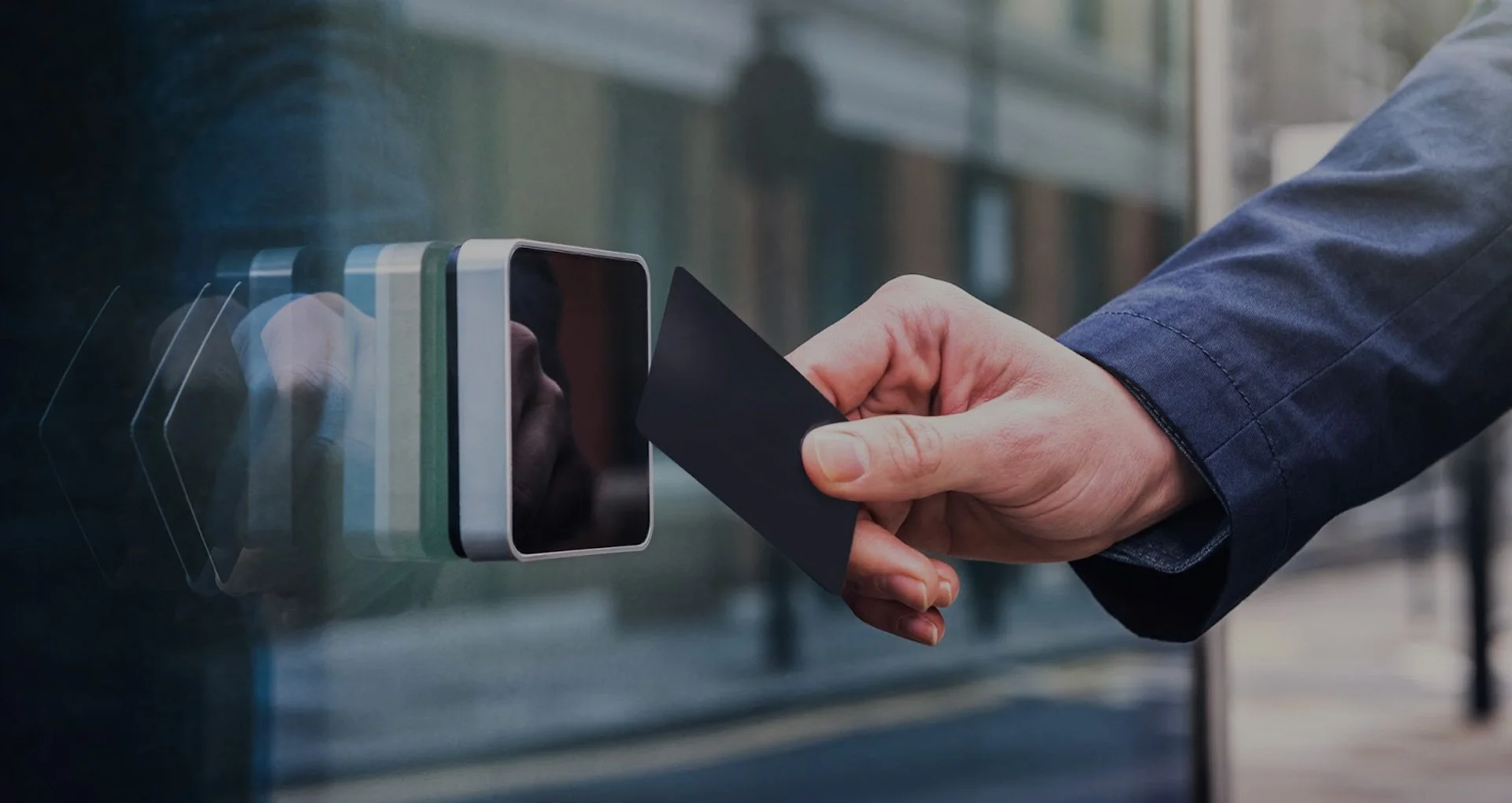 A person using a contactless card to gain access to a building from a electronic card reader