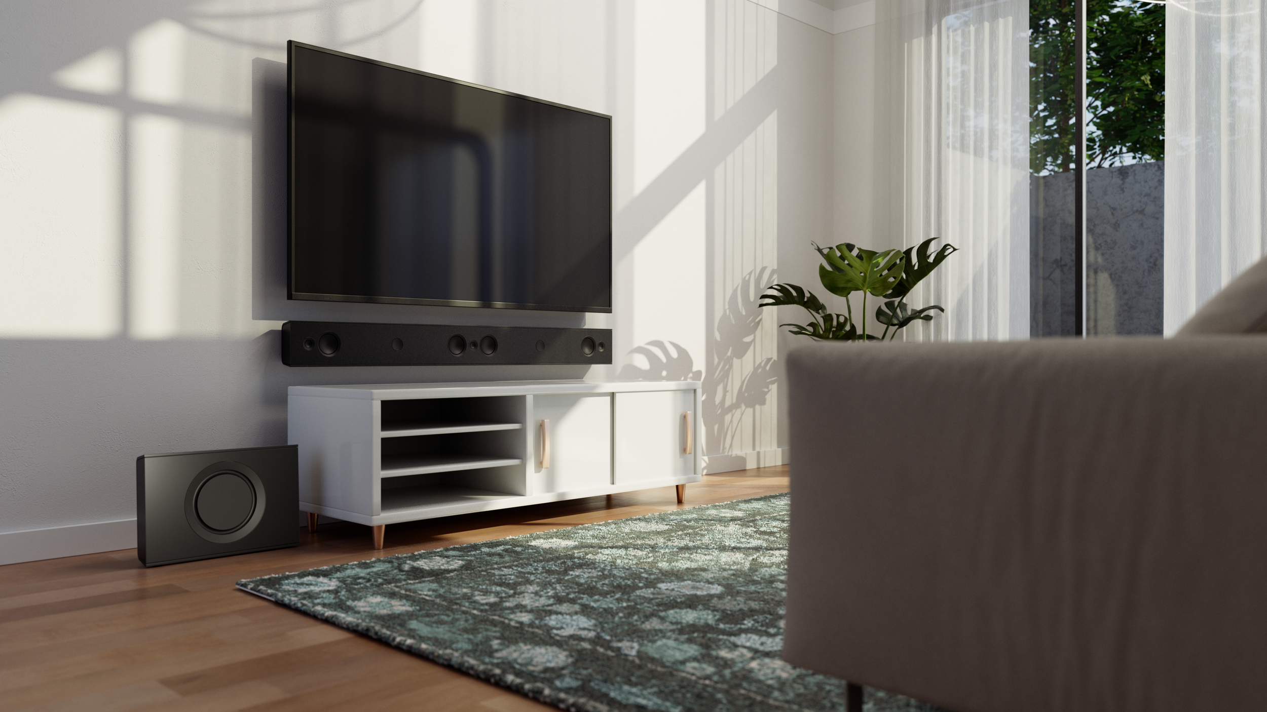 A modern living room with a wall-mounted flat-screen TV, a black soundbar, a subwoofer on the floor, a white media console, a green patterned rug, a potted Monstera plant, and large windows with sheer curtains letting in sunlight.