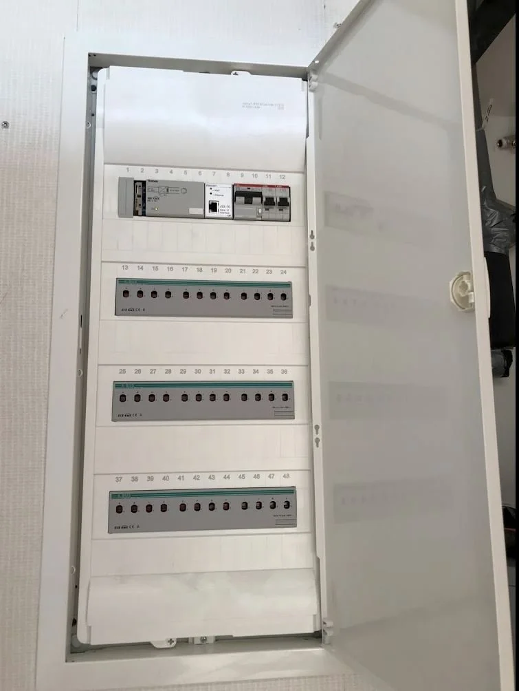 Open electrical panel with circuit breakers and electrical components inside.