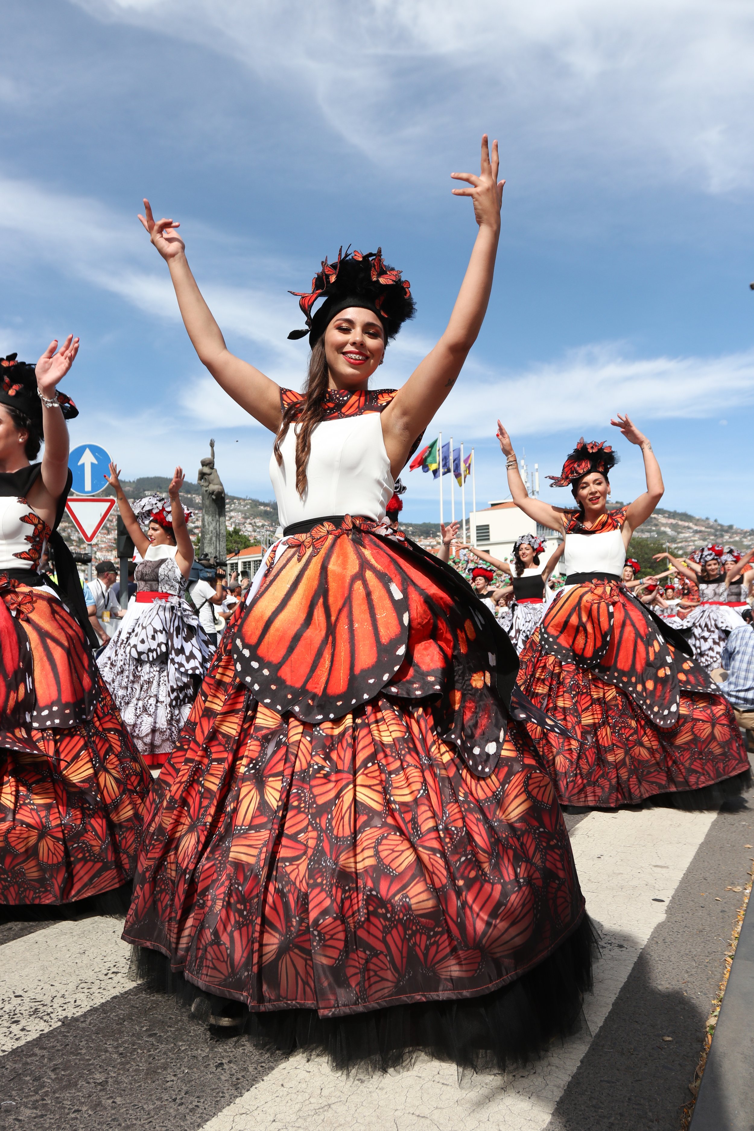 Women dancing in costumes decorated with butterfly wings during a parade