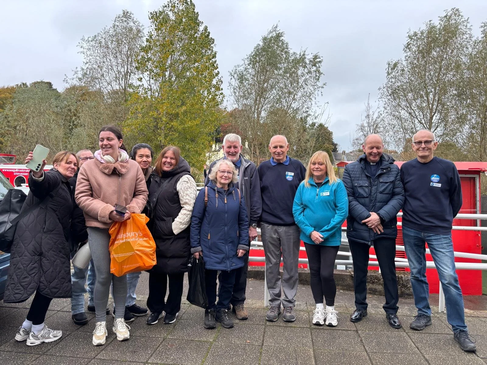 Group of adults standing in front of canal boat