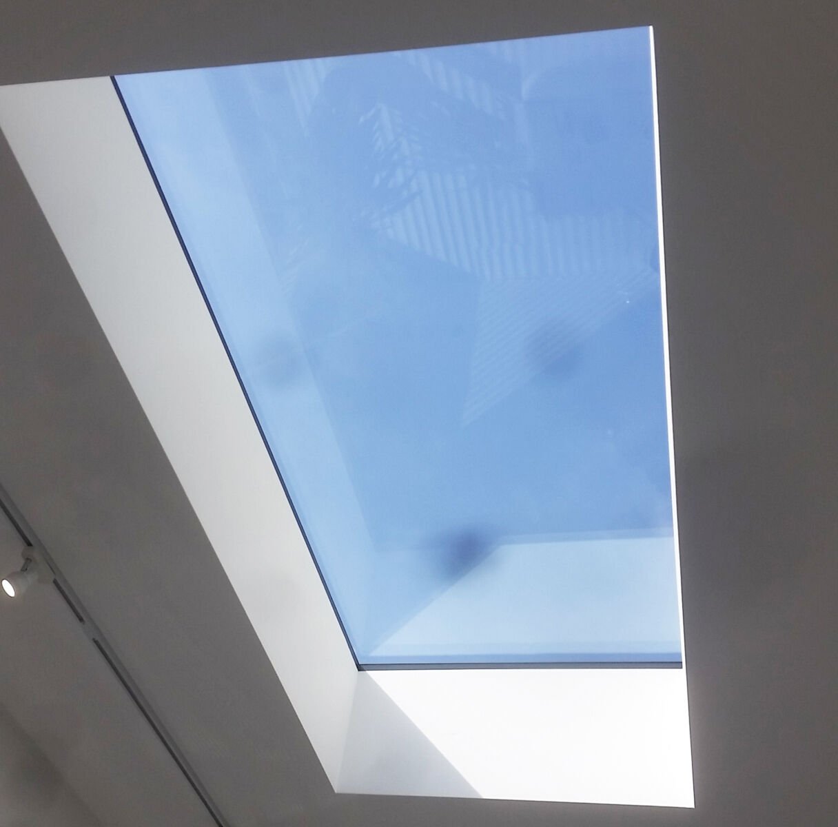 Skylight in a ceiling, showing a clear blue sky