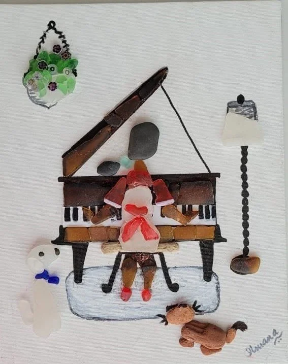 Artistic collage of a person playing the piano, made from small objects and figures, with a dog, a bear, and a hanging lamp illustrated around it.