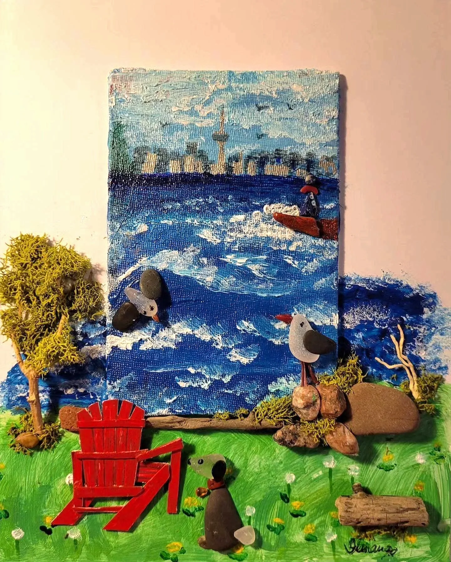 Mixed media art piece depicting Ontario lakeside scene with a painted background of city skyline and water, seen from a backyard, with trees, flowers, a red Muskoka chair, and bird figures in the foreground.