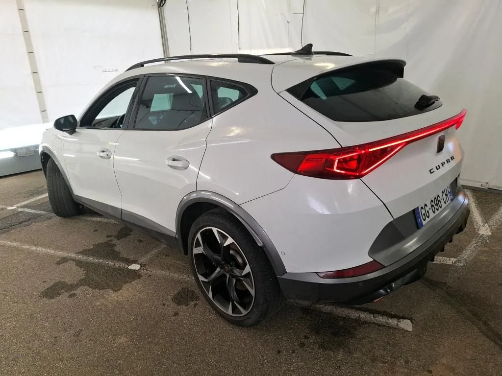 Carro branco do modelo CUPRA estacionado em uma garagem coberta.
