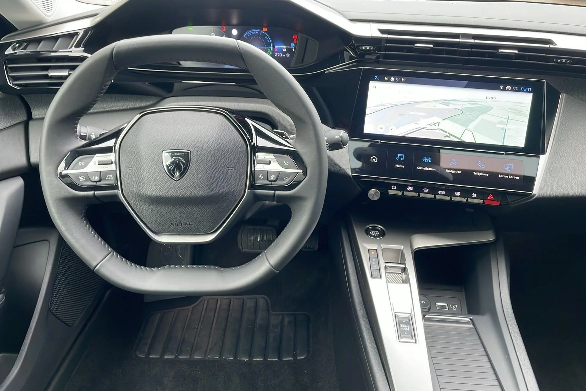 Interior de um carro com volante, painel digital e tela de navegação exibindo um mapa, botões de controle no console central e revestimento em preto.