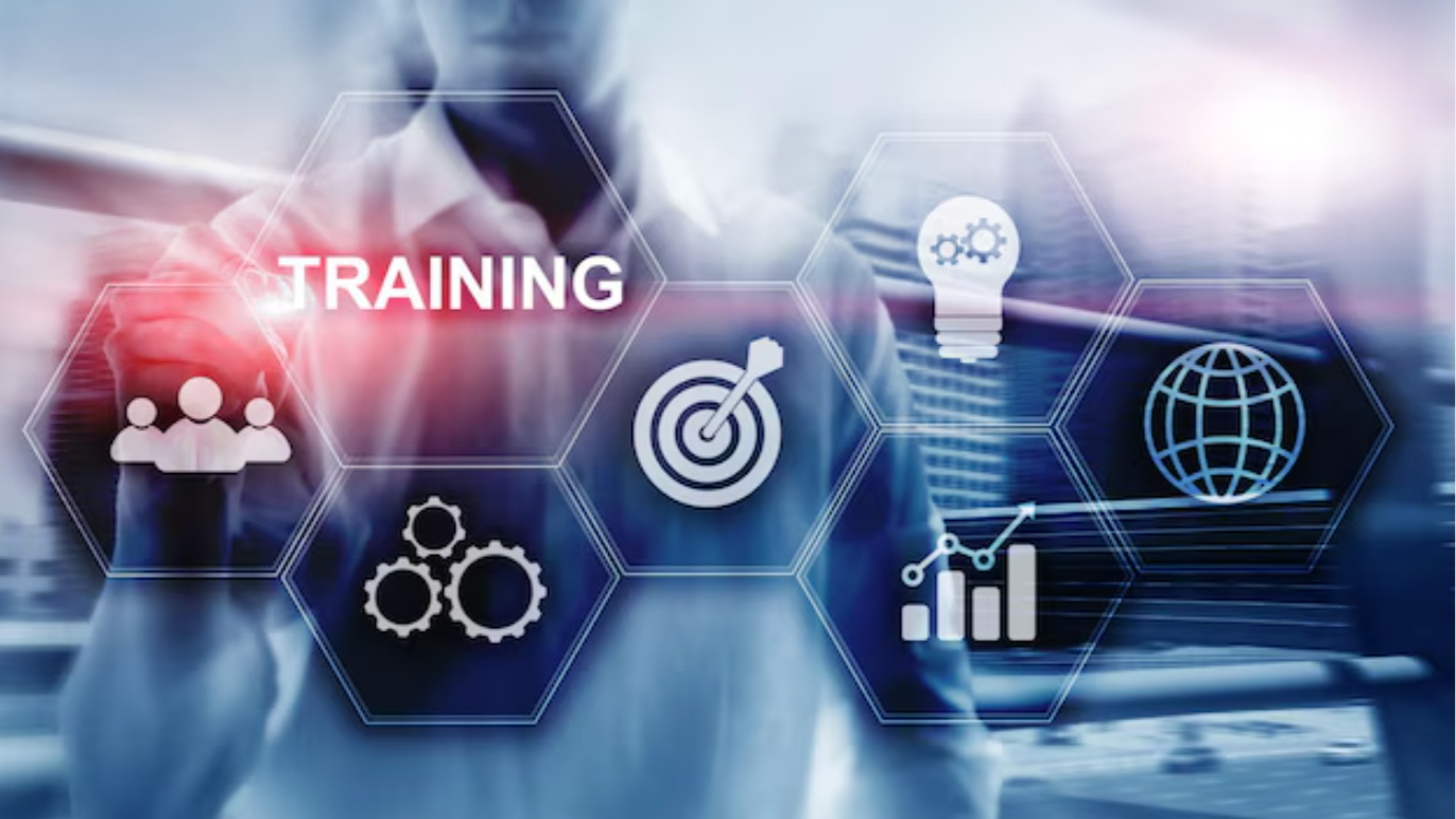 Digital graphic with hexagons containing icons of people, gears, a target, a lightbulb, a globe, and a bar chart, with the word 'TRAINING' in the center and a blurred person in business attire in the background.