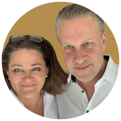 Ein Mann und eine Frau machen ein Selfie vor einem beigen Hintergrund. Beide lachen leicht und schauen in die Kamera.