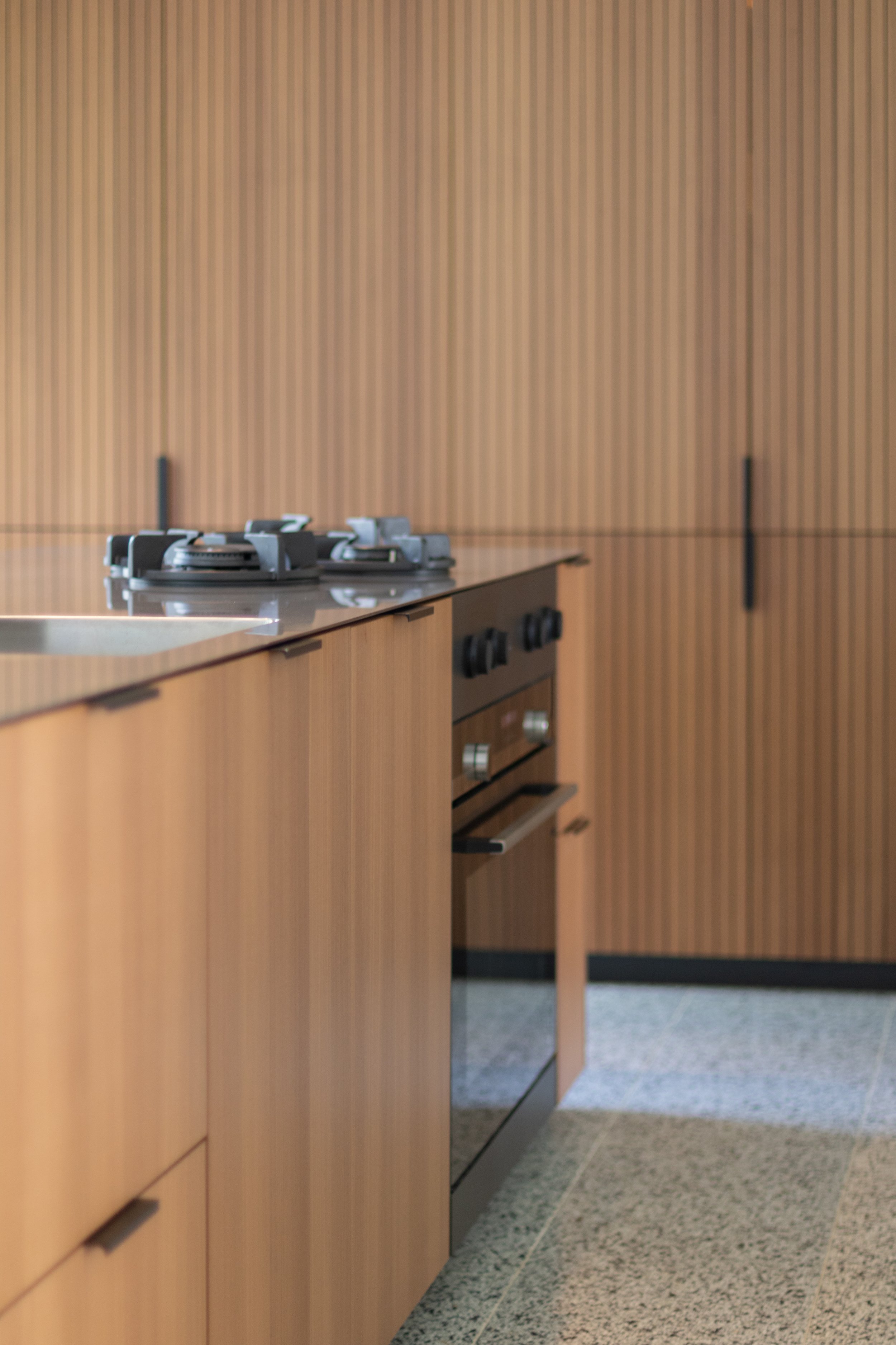 Moderne keuken met houten kasten en een fornuis.