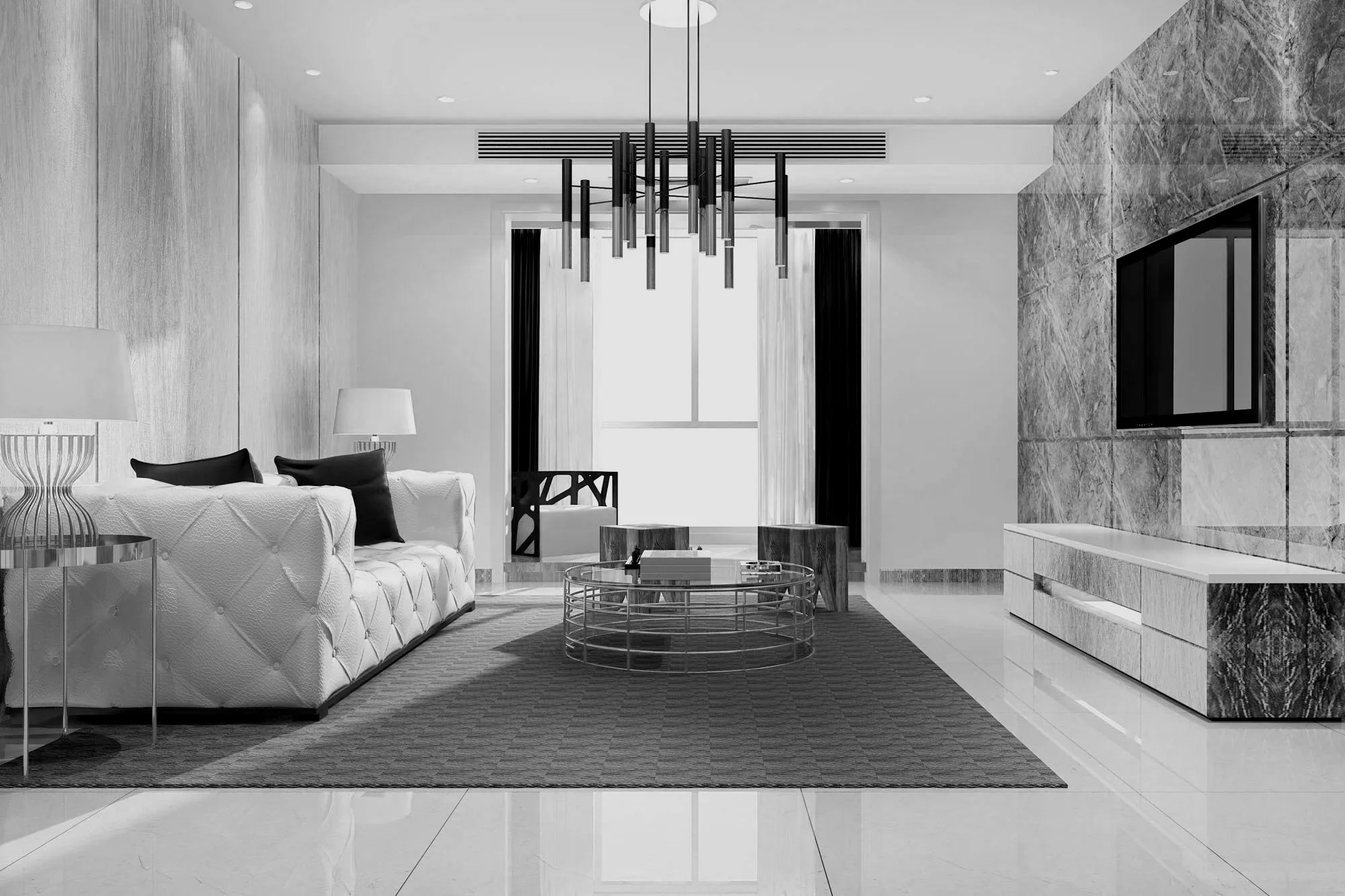 Modern living room with a white tufted sofa, black and white pillows, glass top coffee table, and marble accent wall with a large flat-screen TV. Black and gold accents, a black chandelier, and a large window with black curtains.