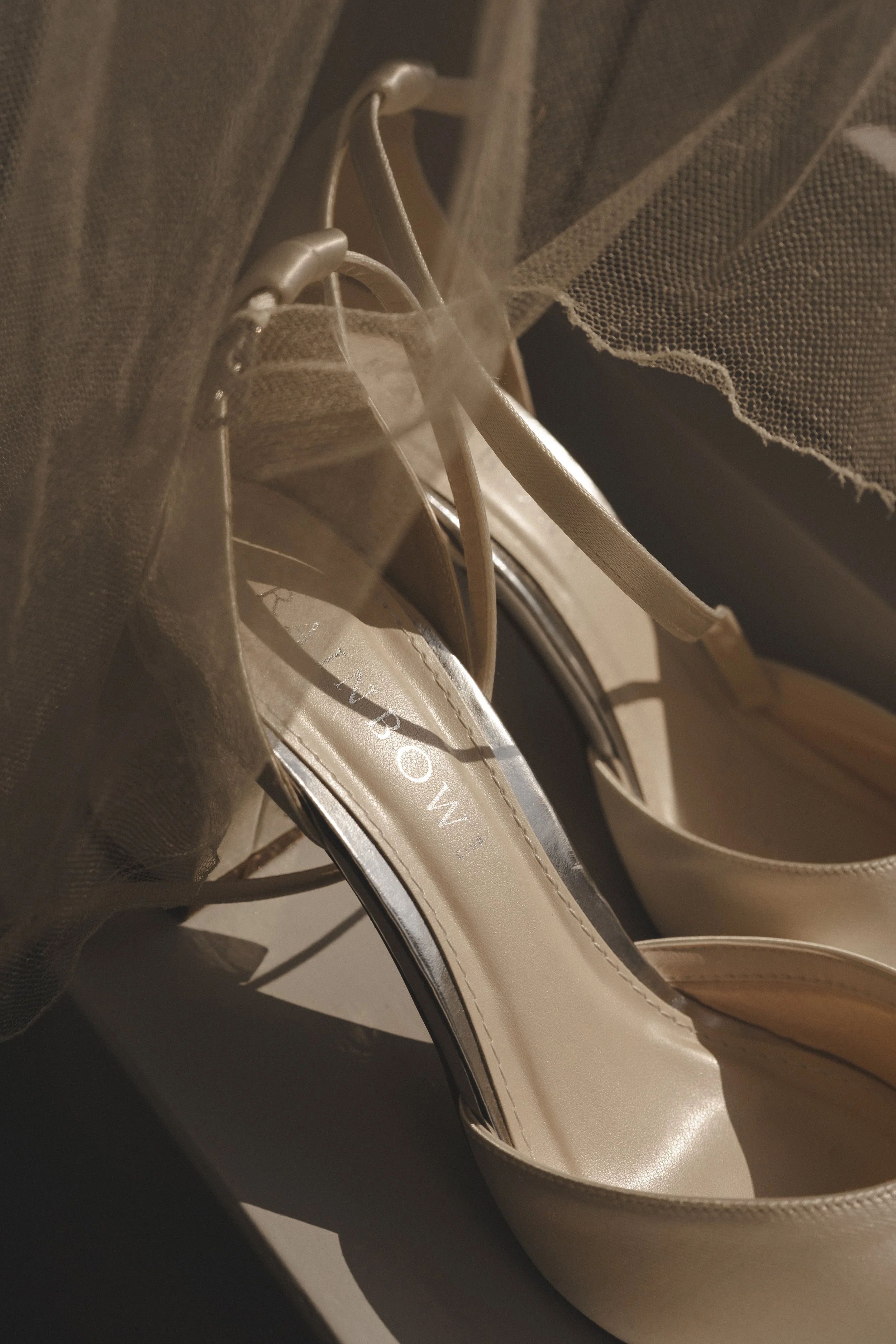 Gouden high heels met merknaam 'MIND' en een beige tasje met tule stof.