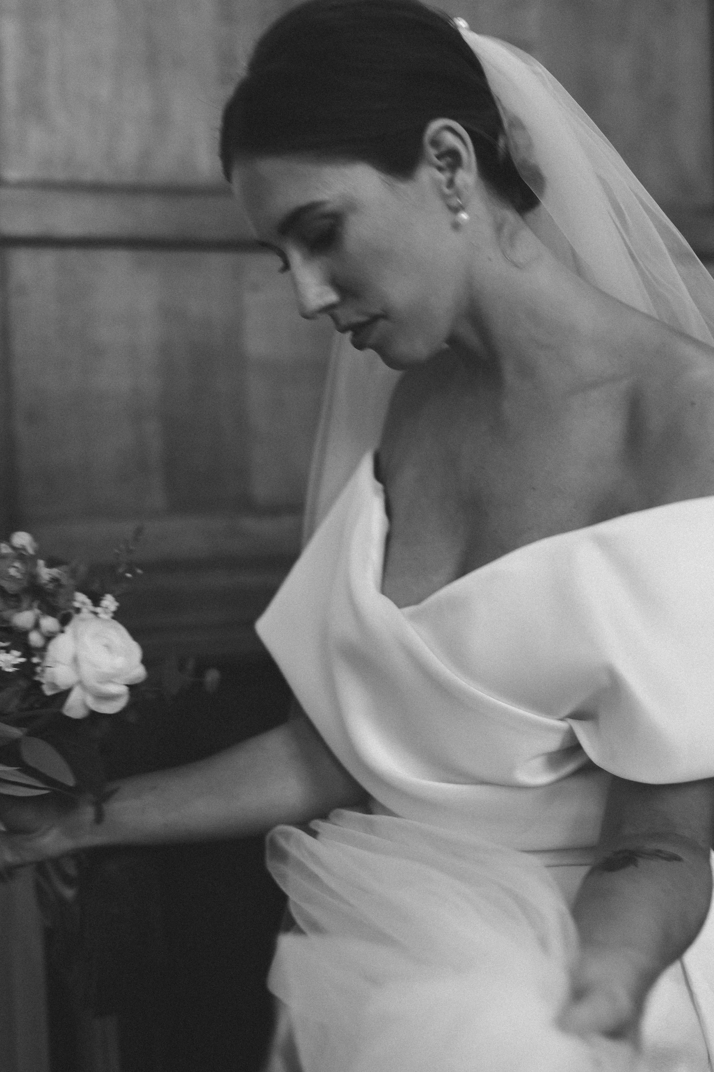 Zweedse bruid in witte jurk met bruidsboeket, nadenkend met gesloten ogen, binnenruimte met houten paneel