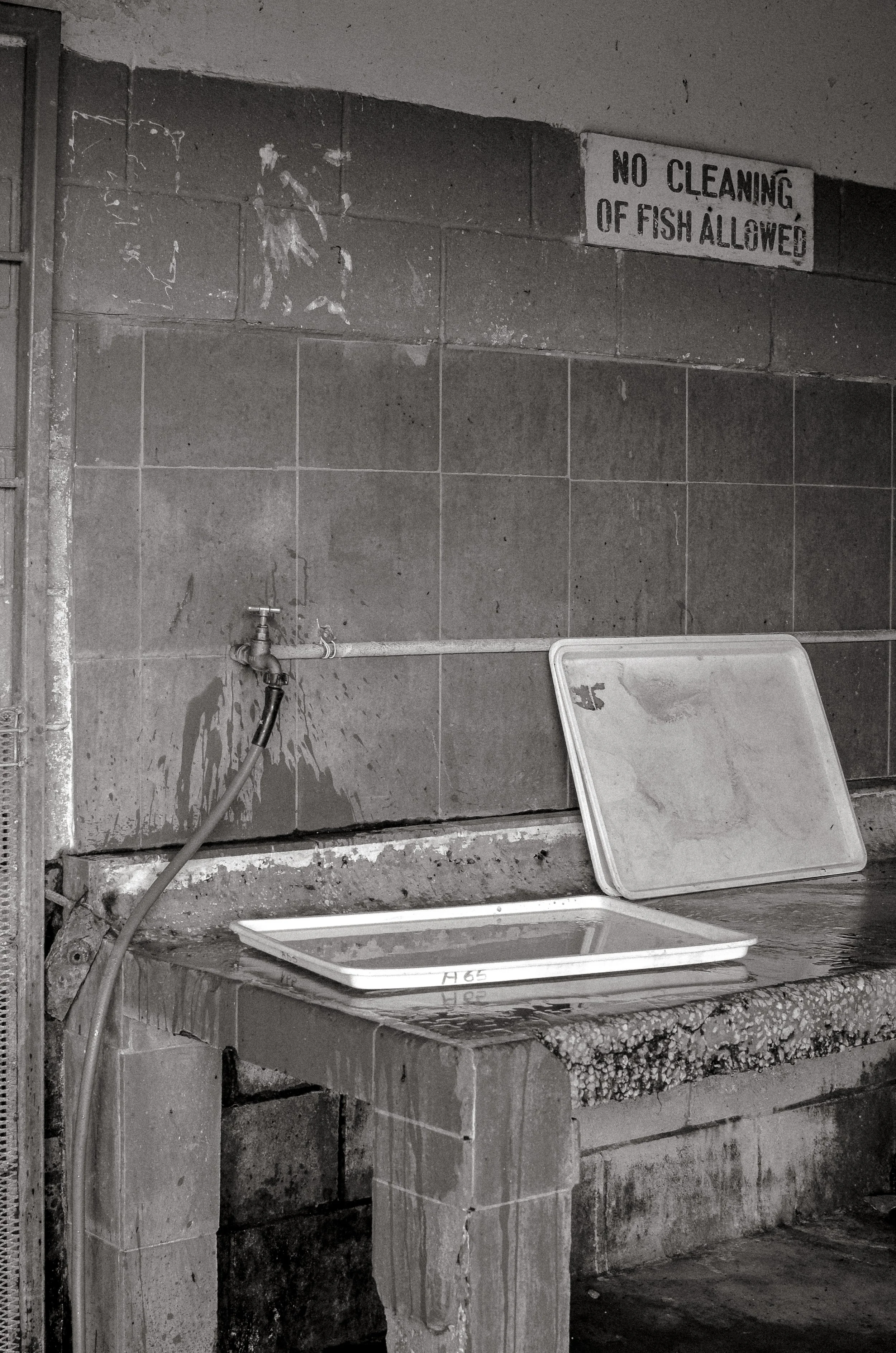 Posted rules beside a wash station inside the processing area. Oistins, Barbados. December 2022.