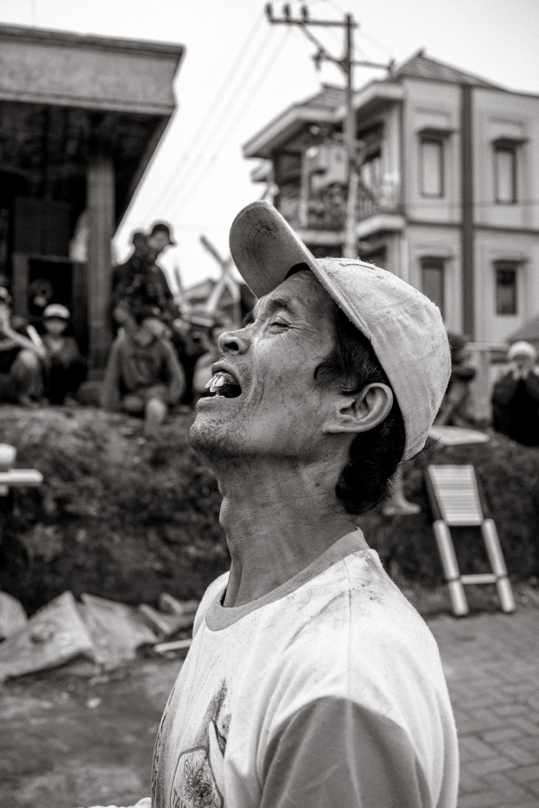 A competitor reacts while looking upward, tracking climbers as the attempt intensifies