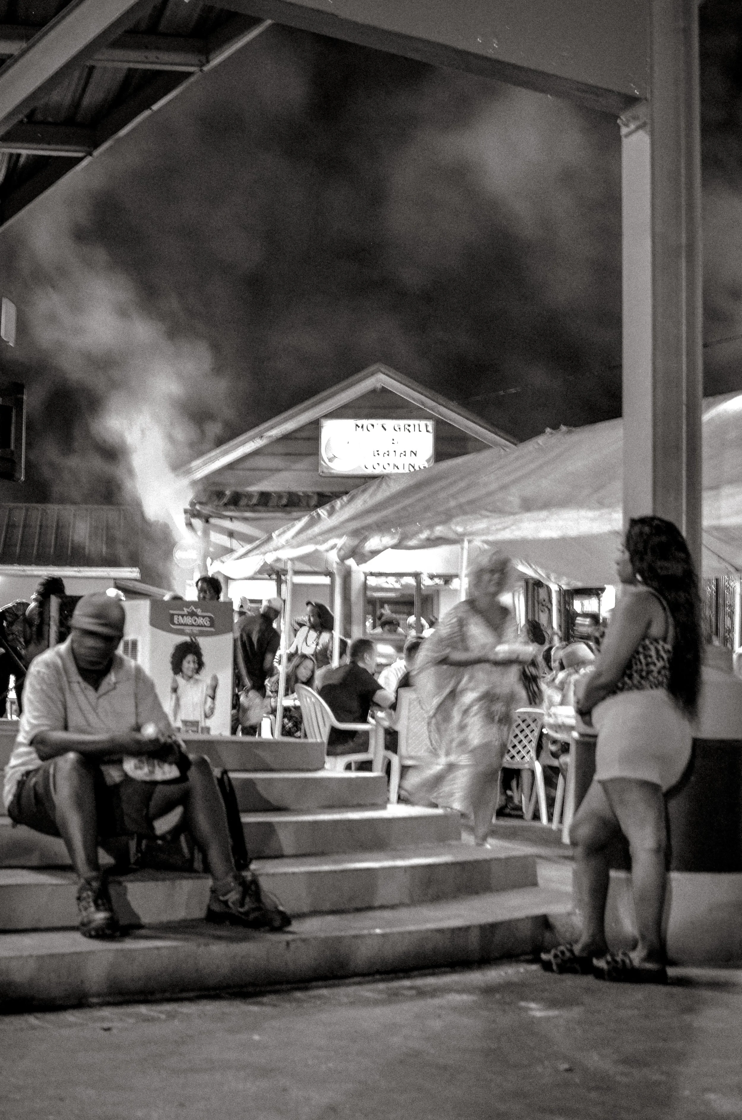 People begin to wait around the stage before the night's performance begins. Oistins, Barbados. December 2022.