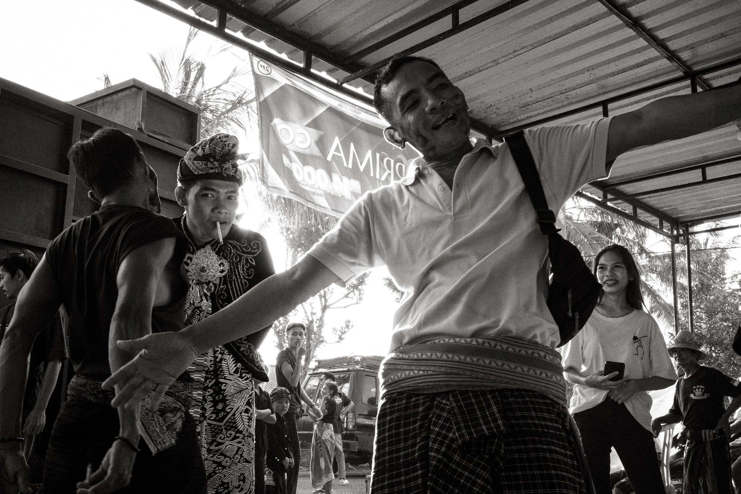 A man dances to music while the groom stands behind him in full Sasak ceremonial dress. Central Lombok, Indonesia. 6 August 2025.