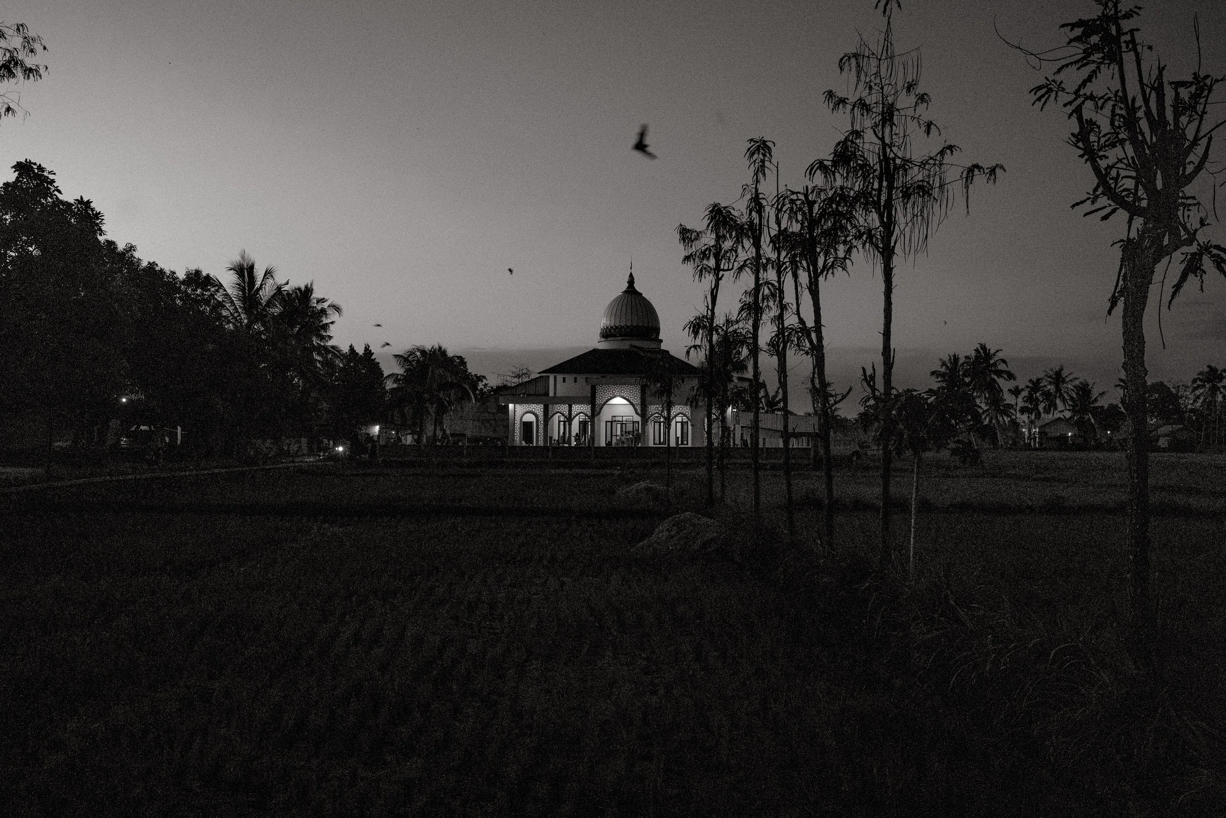 Long after the nyongkolan has ended and the village has returned to calm, men gather at the local mosque for evening prayer. Central Lombok, Indonesia. 6 August 2025.