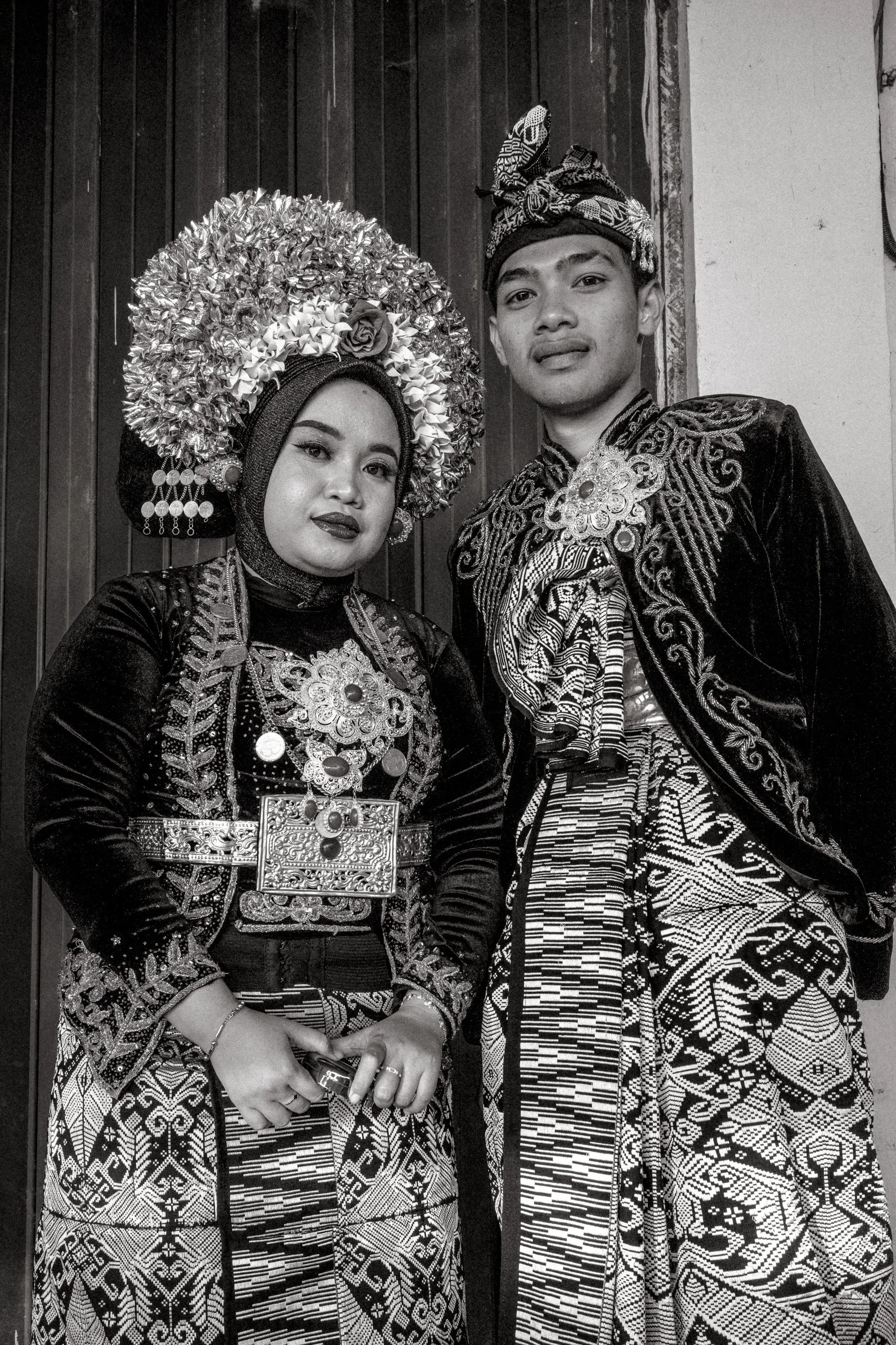 The bride and groom pose in ceremonial Sasak dress