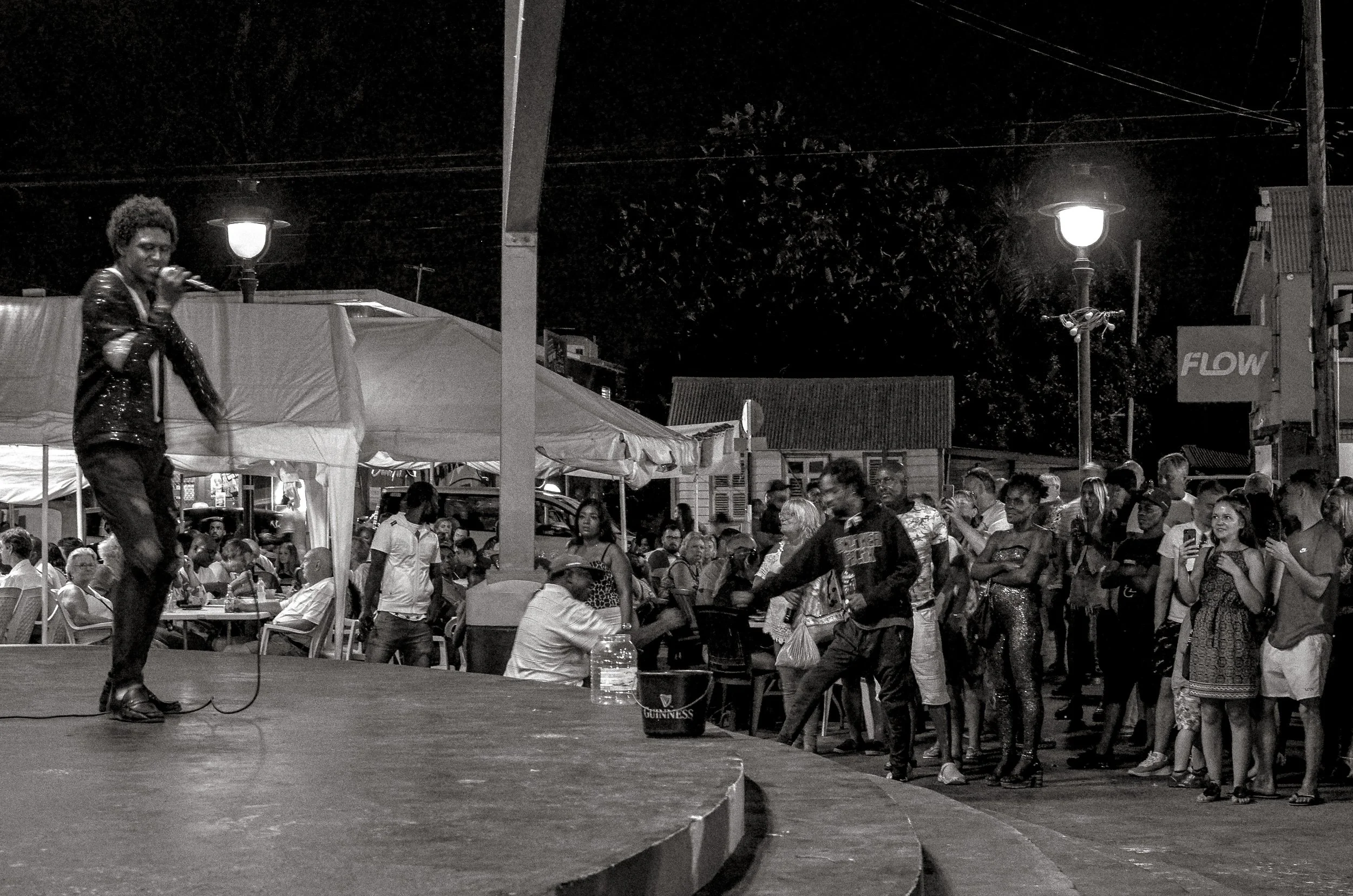 A singer works the stage as spectators watch from the edge. Oistins, Barbados. December 2022.