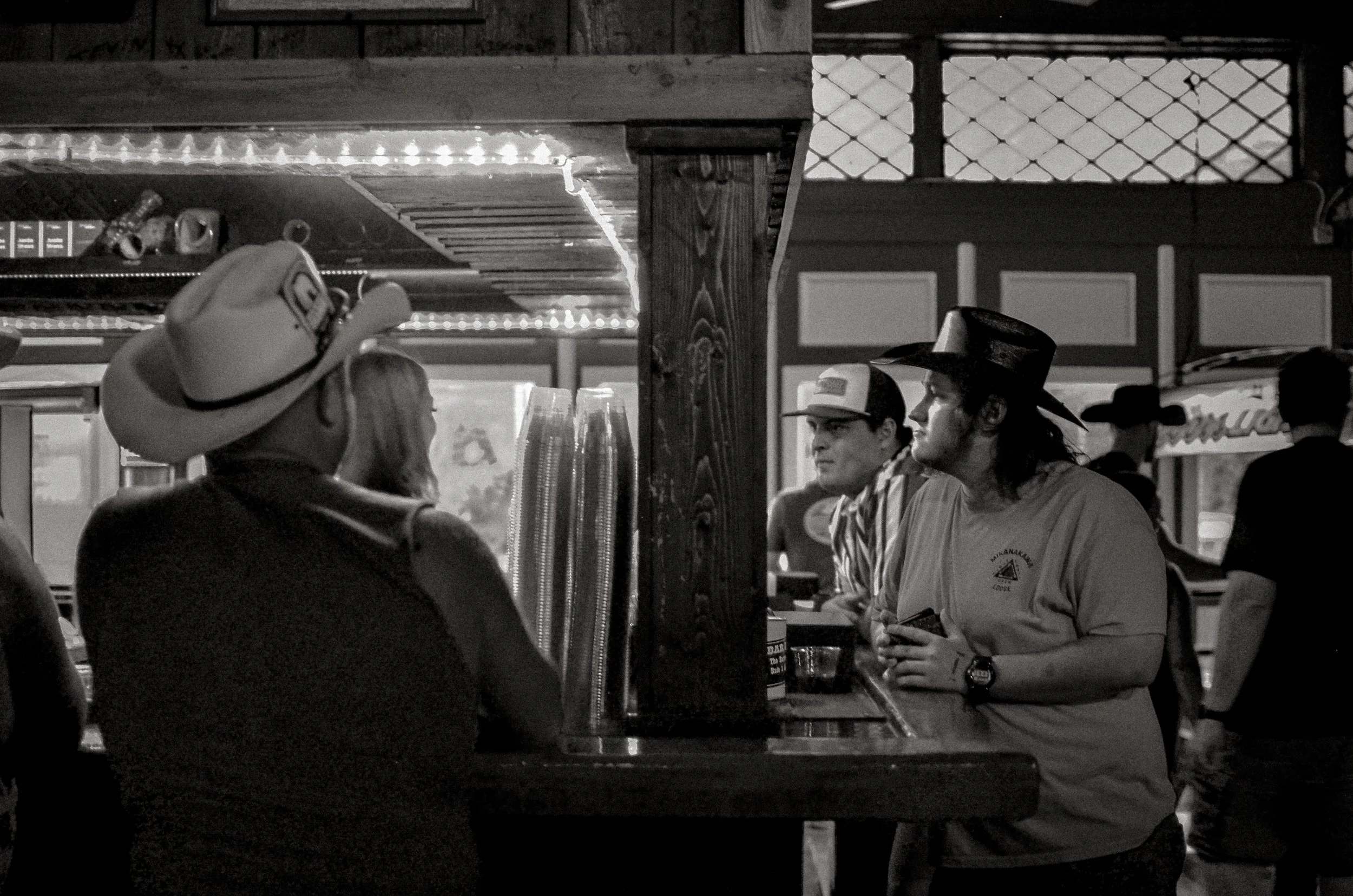 Patrons in cowboy hats stand at the bar. Fort Worth, Texas, USA. 10 August 2023.