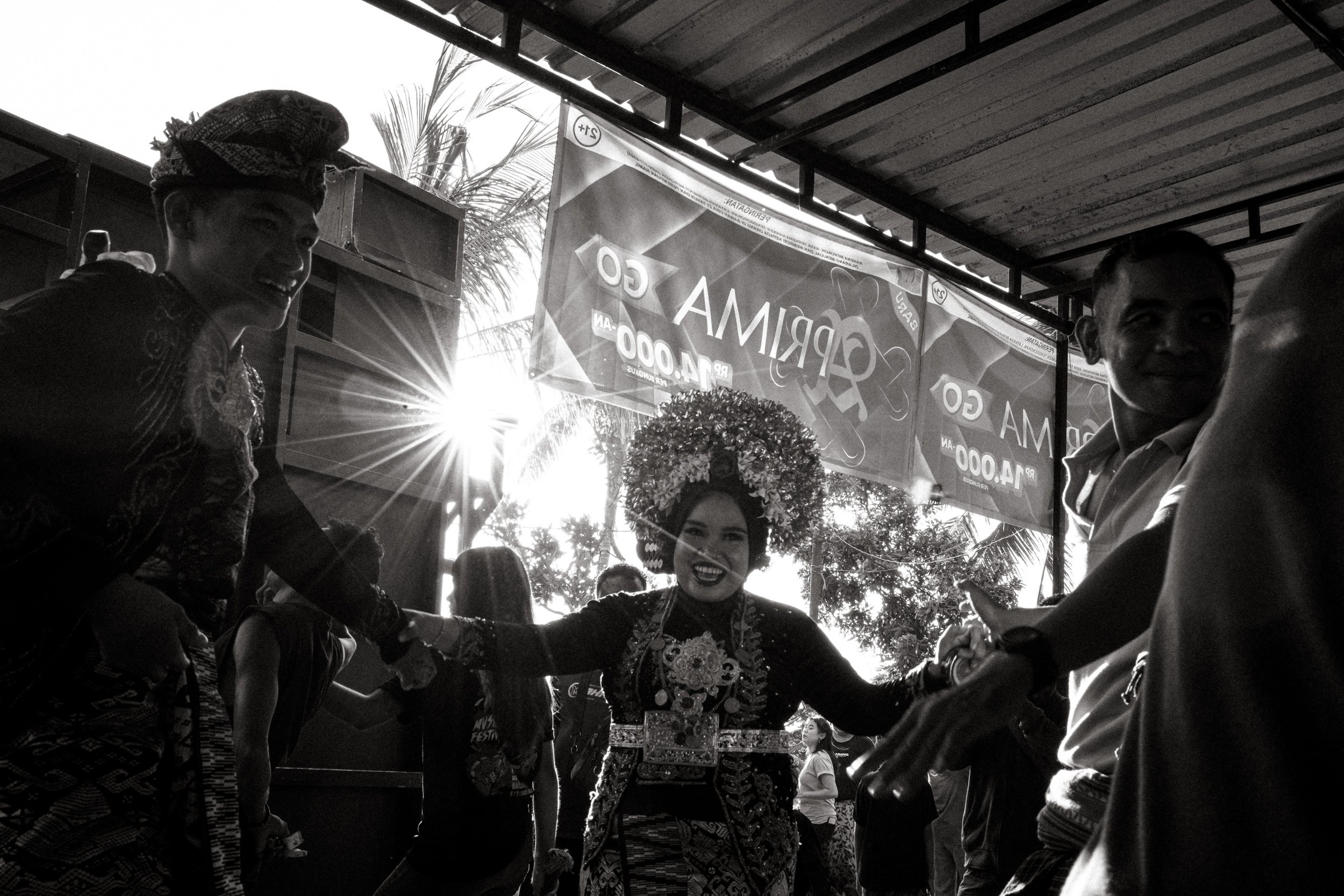 The bride and groom dance at the centre of a loose circle, hands held by relatives on both sides