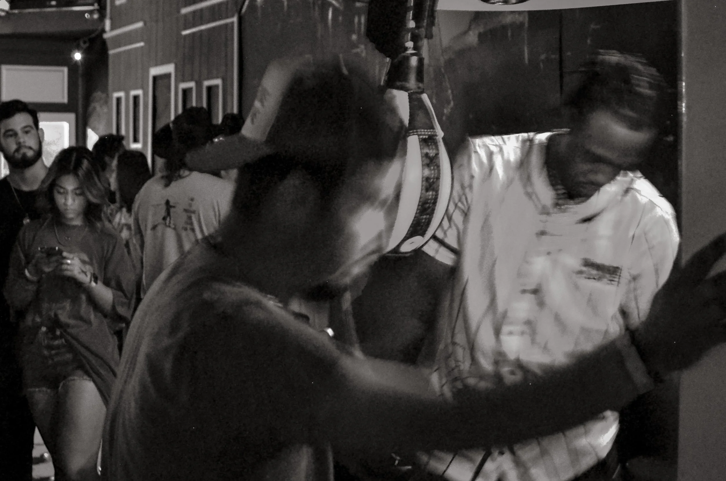 Men strike a punchbag machine as others watch. Fort Worth, Texas, USA. 10 August 2023.