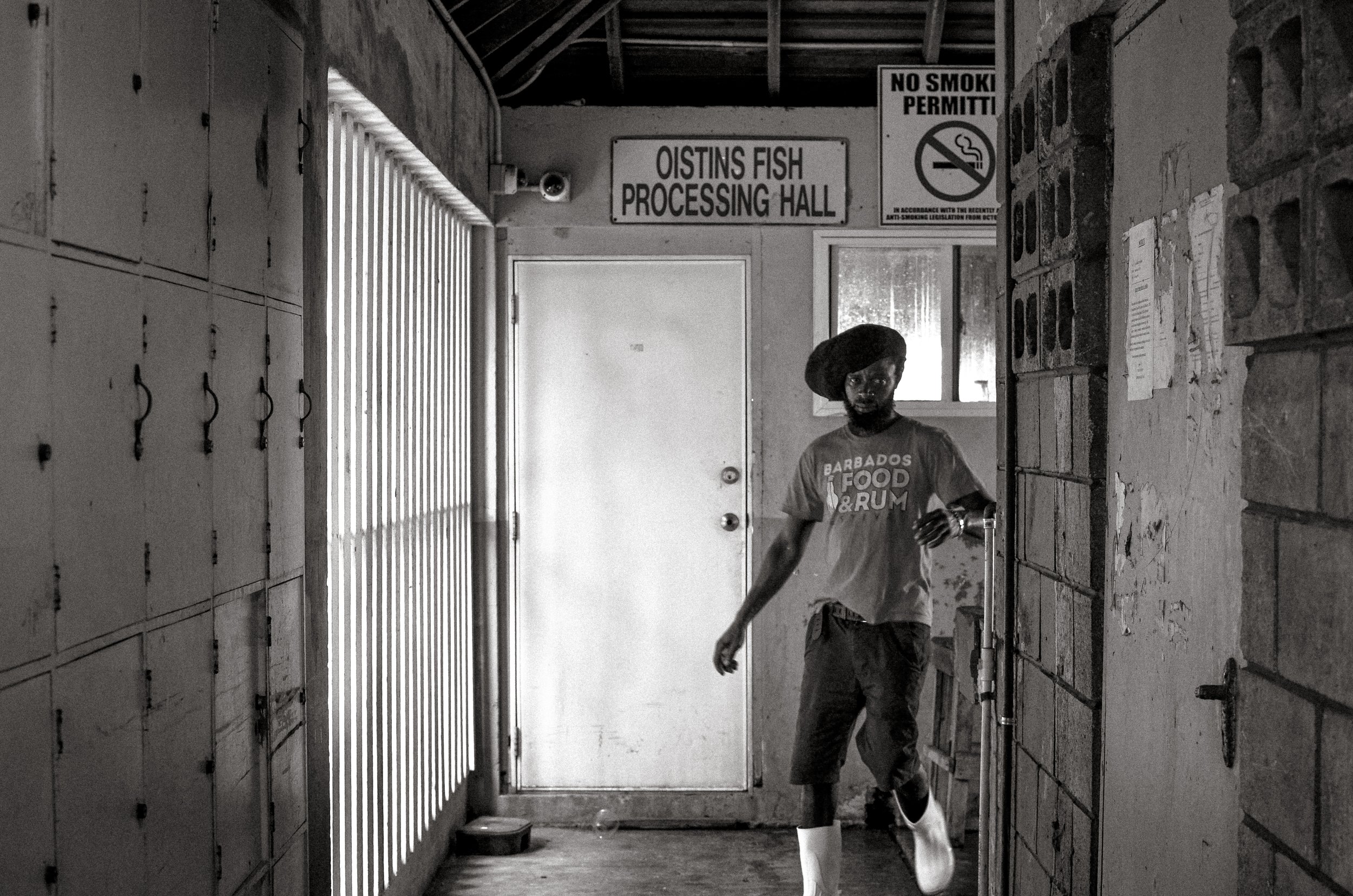 A fisherman inside the fish processing hall. Oistins, Barbados. December 2022.