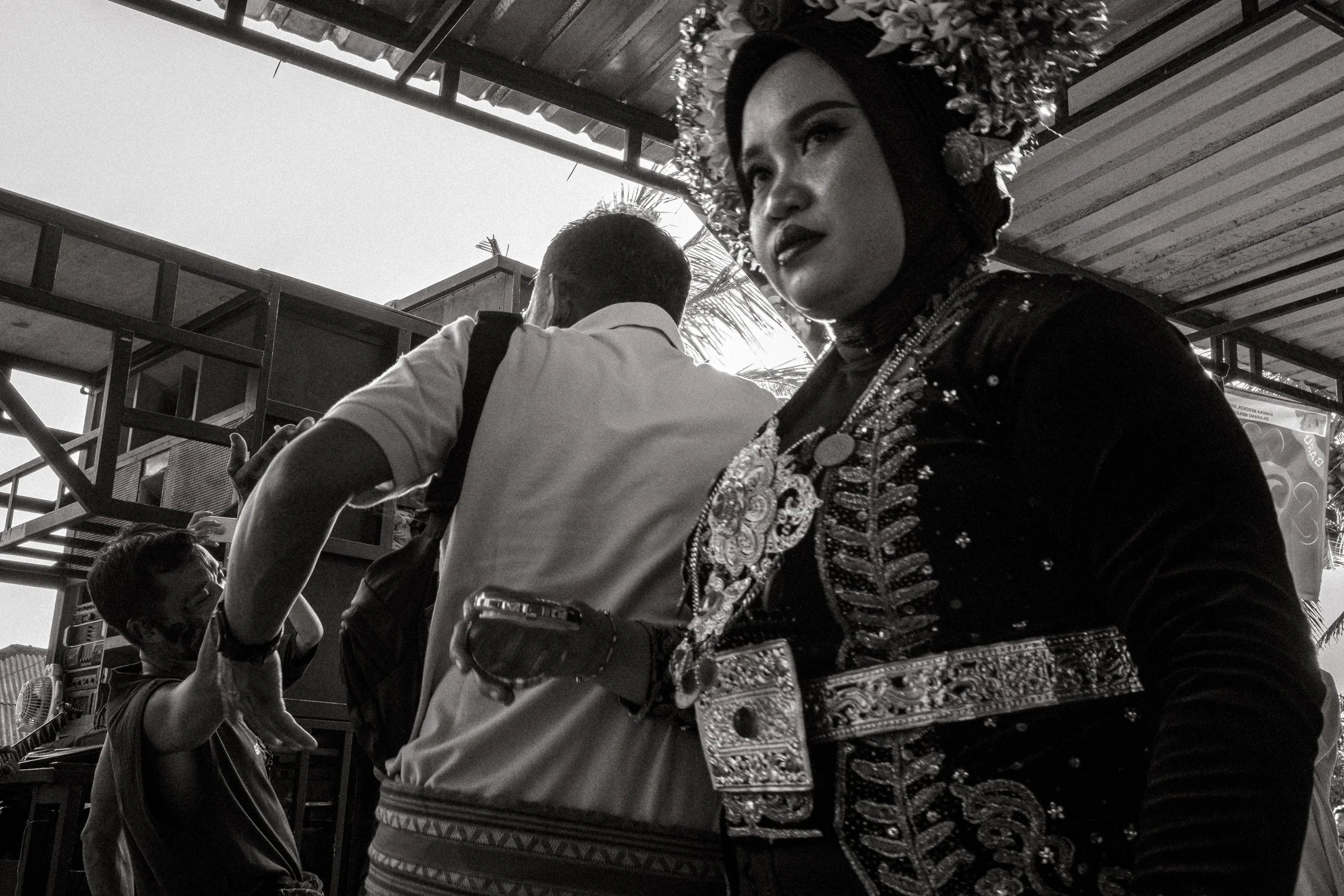 The bride moves through the dance area holding a small case. Central Lombok, Indonesia. 6 August 2025.