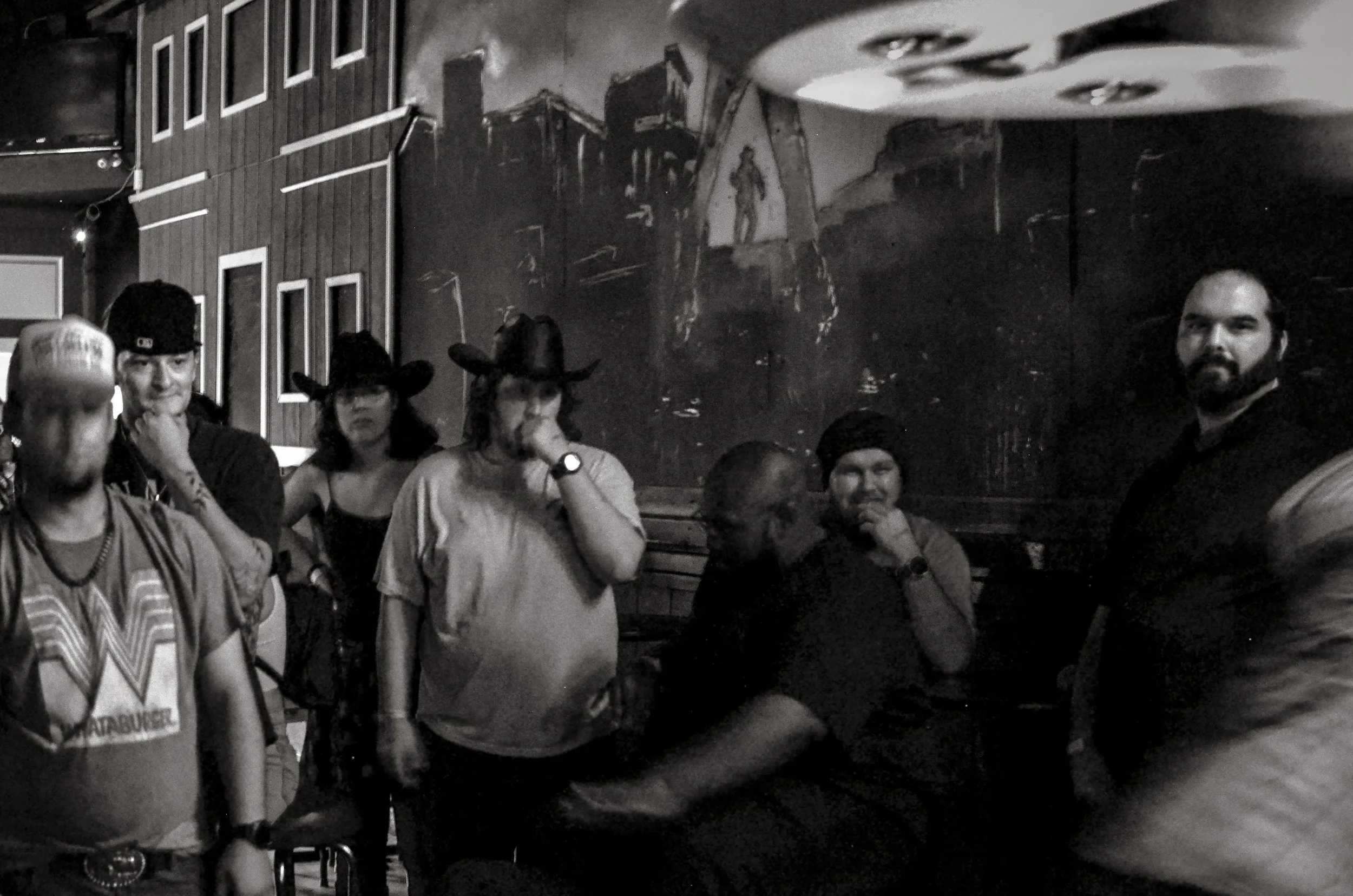Group in a saloon bar watch a punchbag game, faces turned towards the action. Fort Worth, Texas, USA. 10 August 2023.