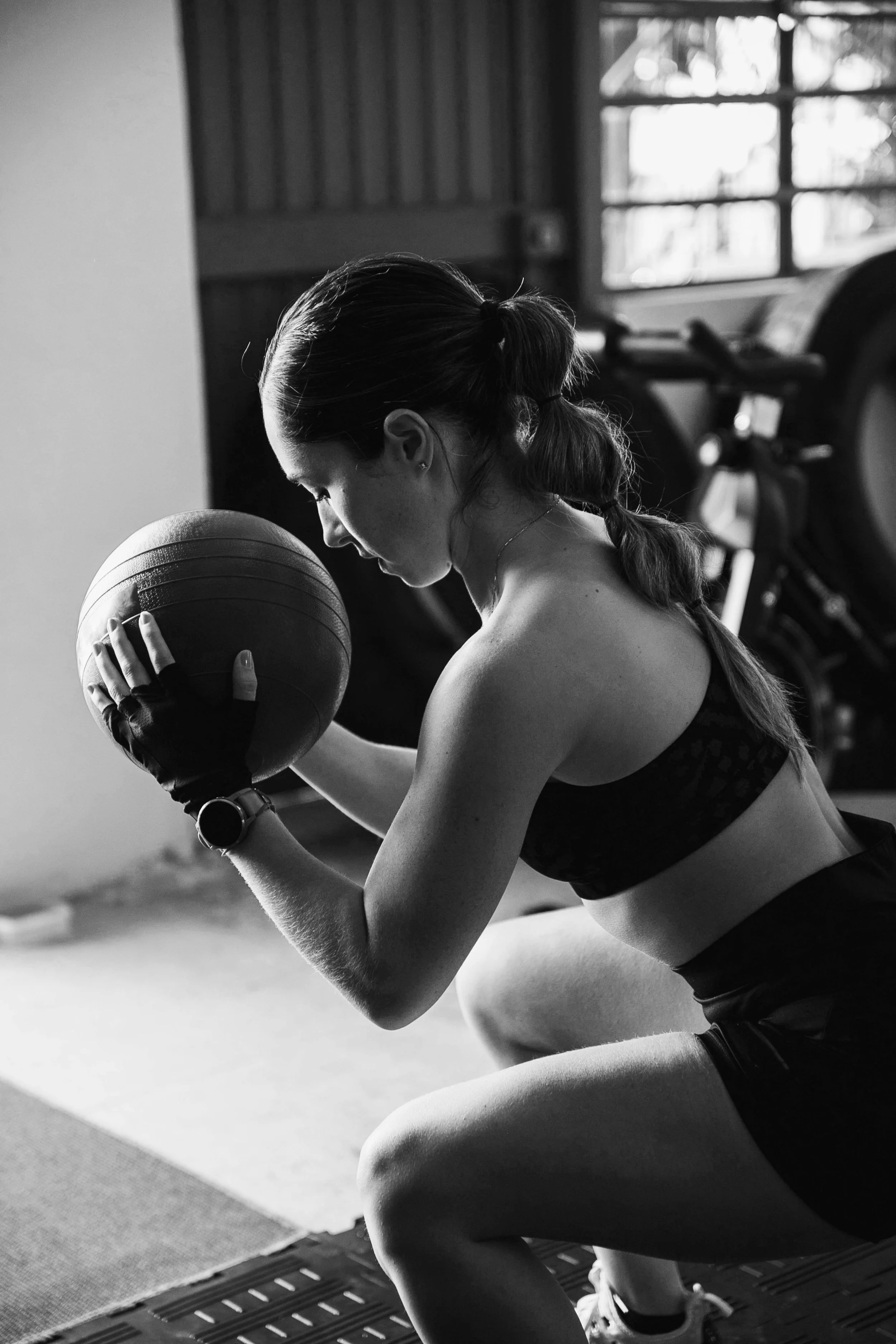 Eine Frau trainiert im Fitnessstudio mit einem Medizinball.
